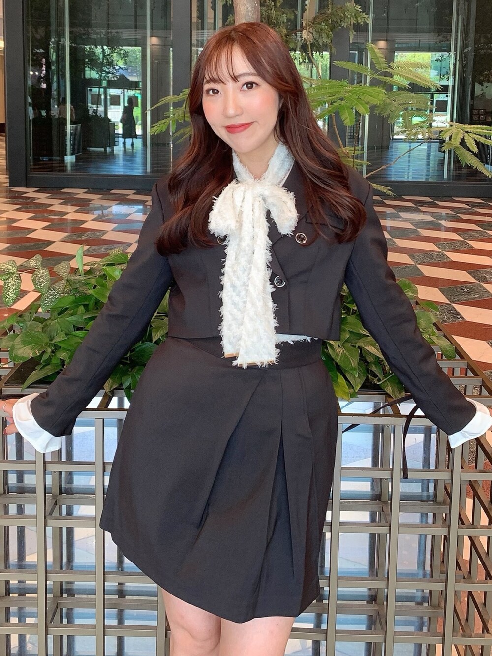 ブラック系のスカート、ブラック系のテーラードジャケット、ベージュ系のブーツを着用したレディースの秋コーディネートの9枚目の写真