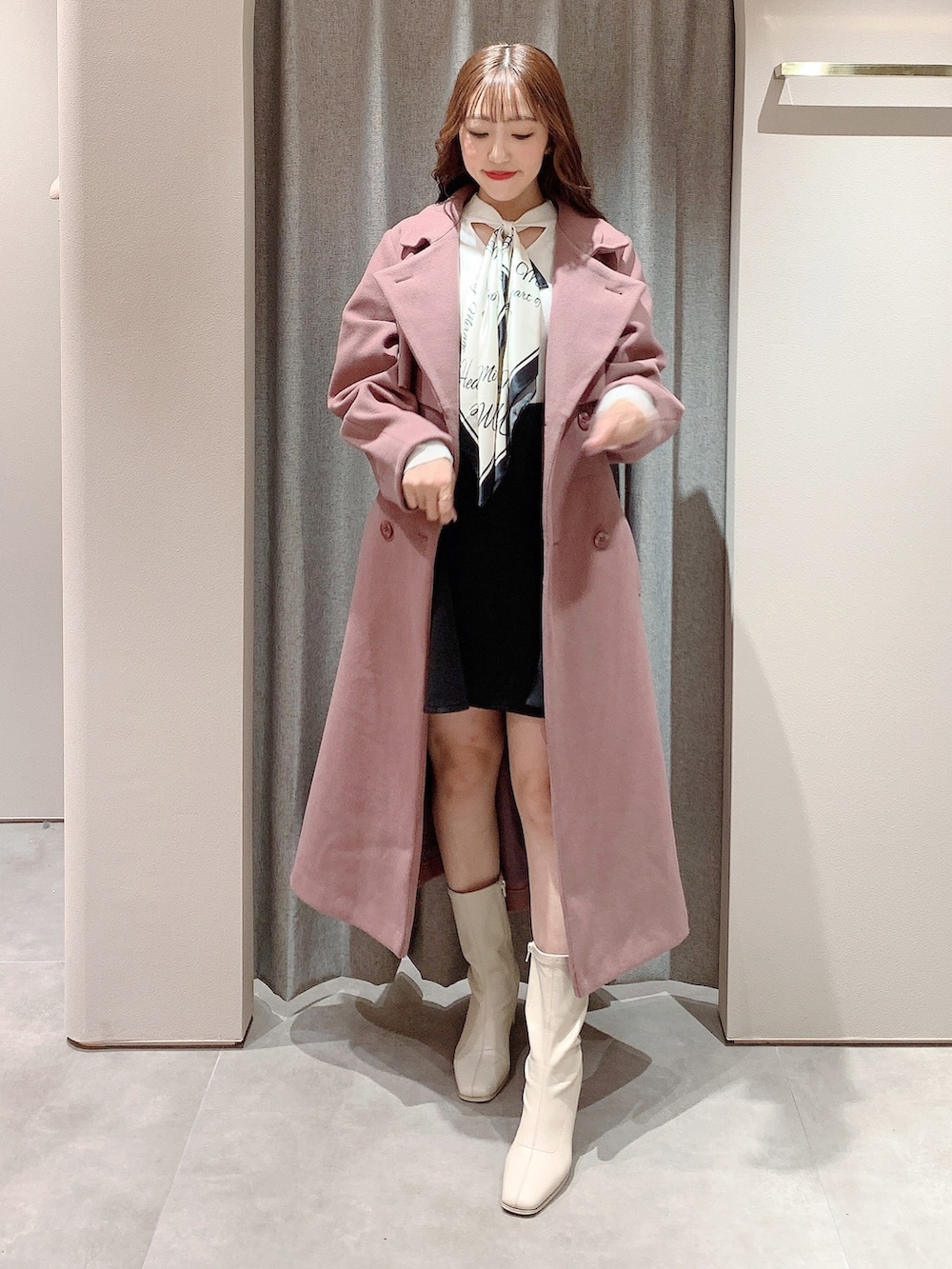 ピンク系のその他アウター、ホワイト系のブーツ、ホワイト系のニット/セーターを着用したレディースの秋コーディネートの2枚目の写真