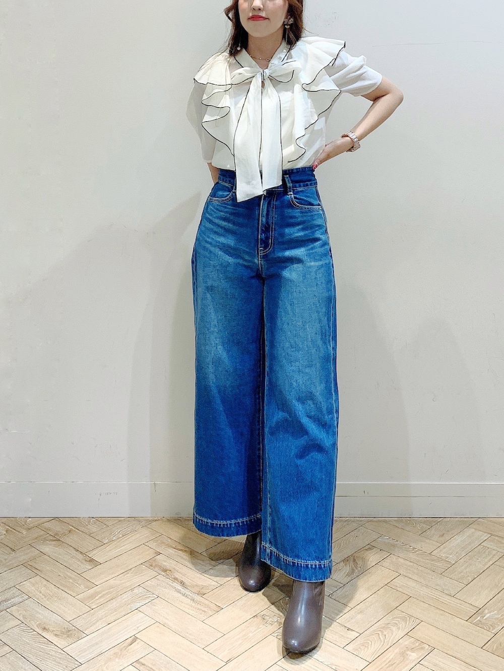 ホワイト系のシャツ/ブラウス、ブラウン系のブーツ、ブルー系のデニムパンツを着用したレディースの夏コーディネートの3枚目の写真