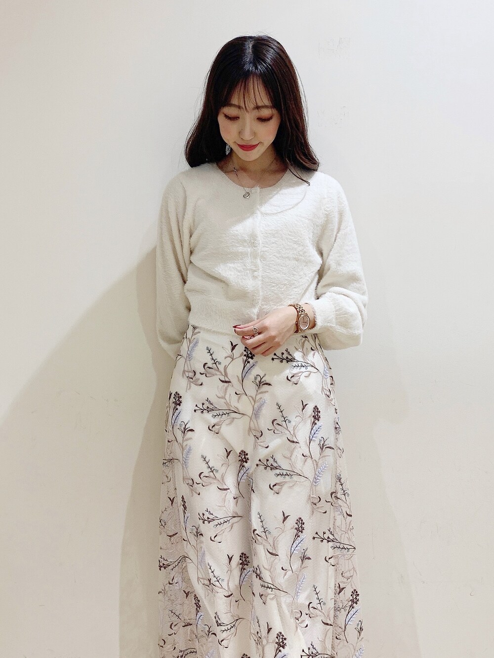 ピンク系のスカート、ホワイト系のカーディガン/ボレロ、ホワイト系のブーツを着用したレディースの秋コーディネートの7枚目の写真