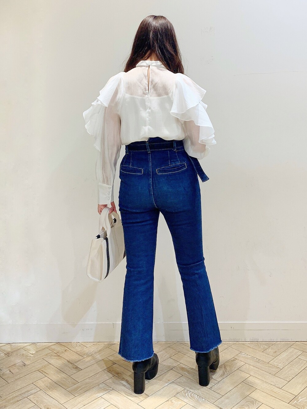 ホワイト系のシャツ/ブラウス、ブルー系のデニムパンツ、ホワイト系のハンドバッグを着用したレディースの冬コーディネートの5枚目の写真