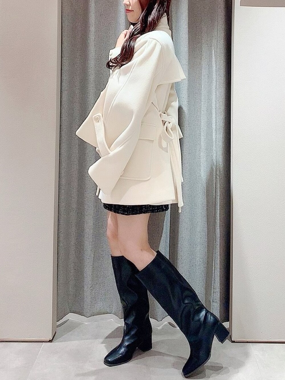 ホワイト系のダッフルコート、ホワイト系のニット/セーター、ブラック系のスカートを着用したレディースの秋コーディネートの3枚目の写真