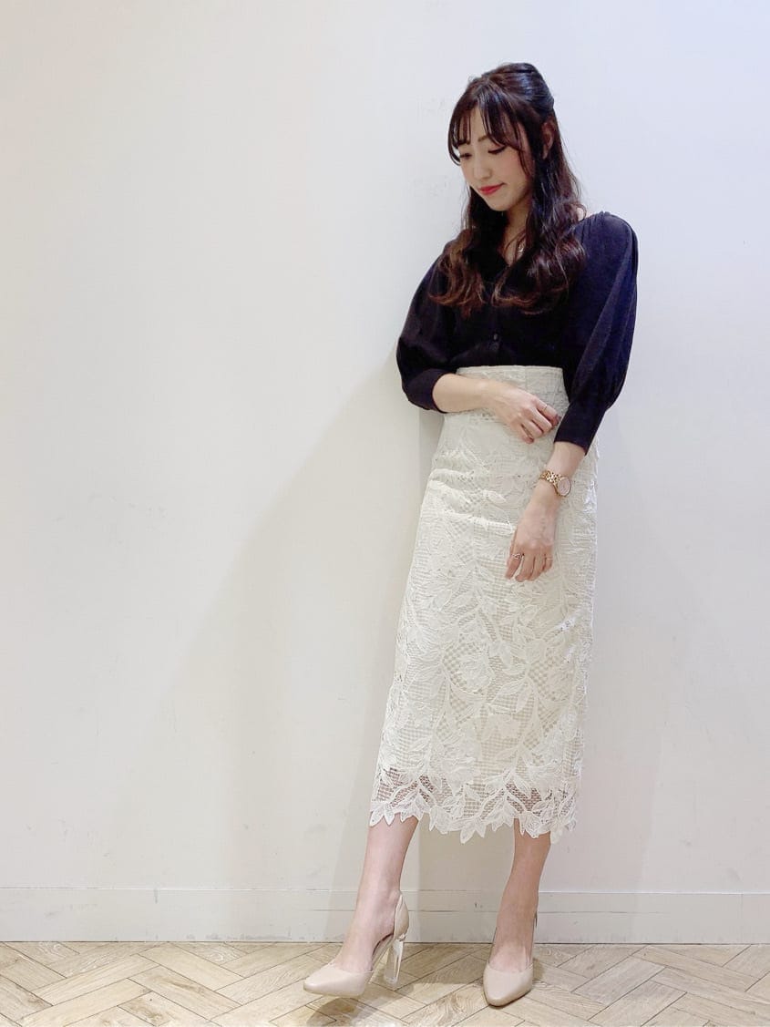 ベージュ系のパンプス、ホワイト系のスカート、ベージュ系のトレンチコートを着用したレディースの春コーディネートの2枚目の写真