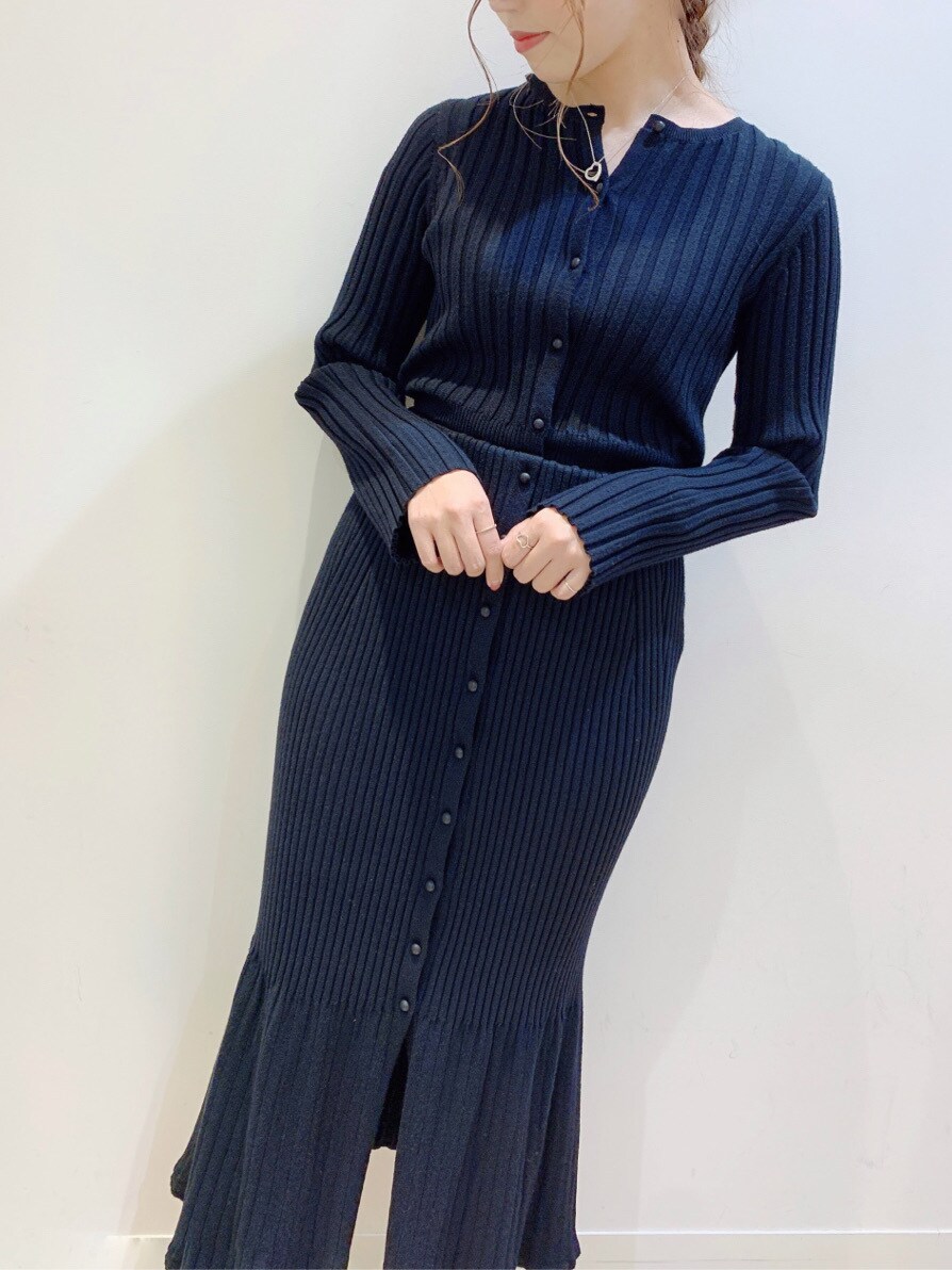 レッド系のハンドバッグ、ブラック系のスカート、グリーン系のサンダルを着用したレディースの春コーディネートの3枚目の写真