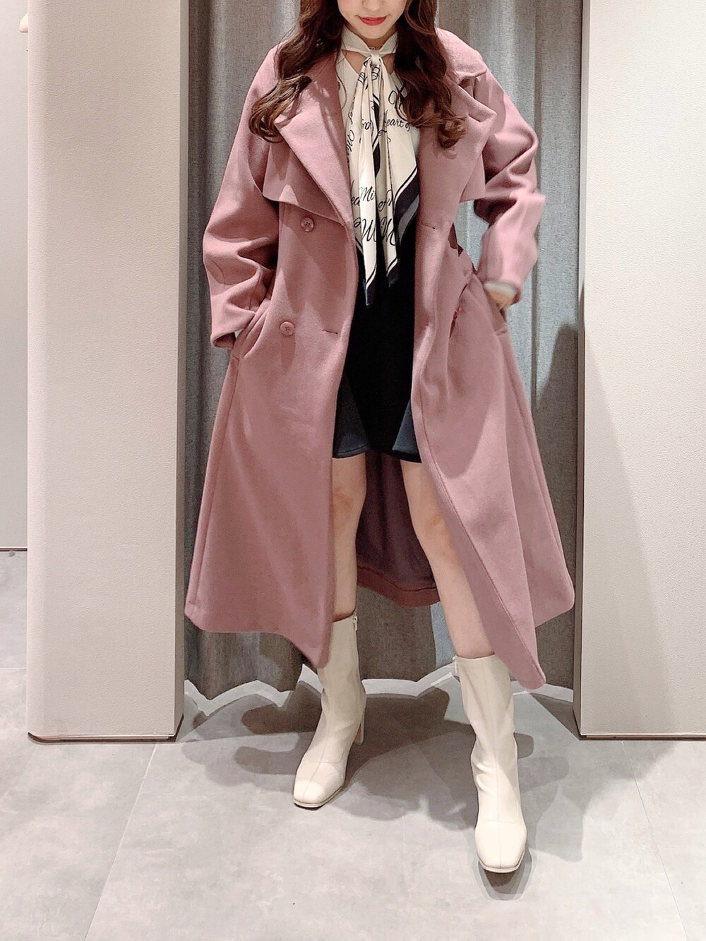 ピンク系のその他アウター、ホワイト系のブーツ、ホワイト系のニット/セーターを着用したレディースの秋コーディネートの3枚目の写真