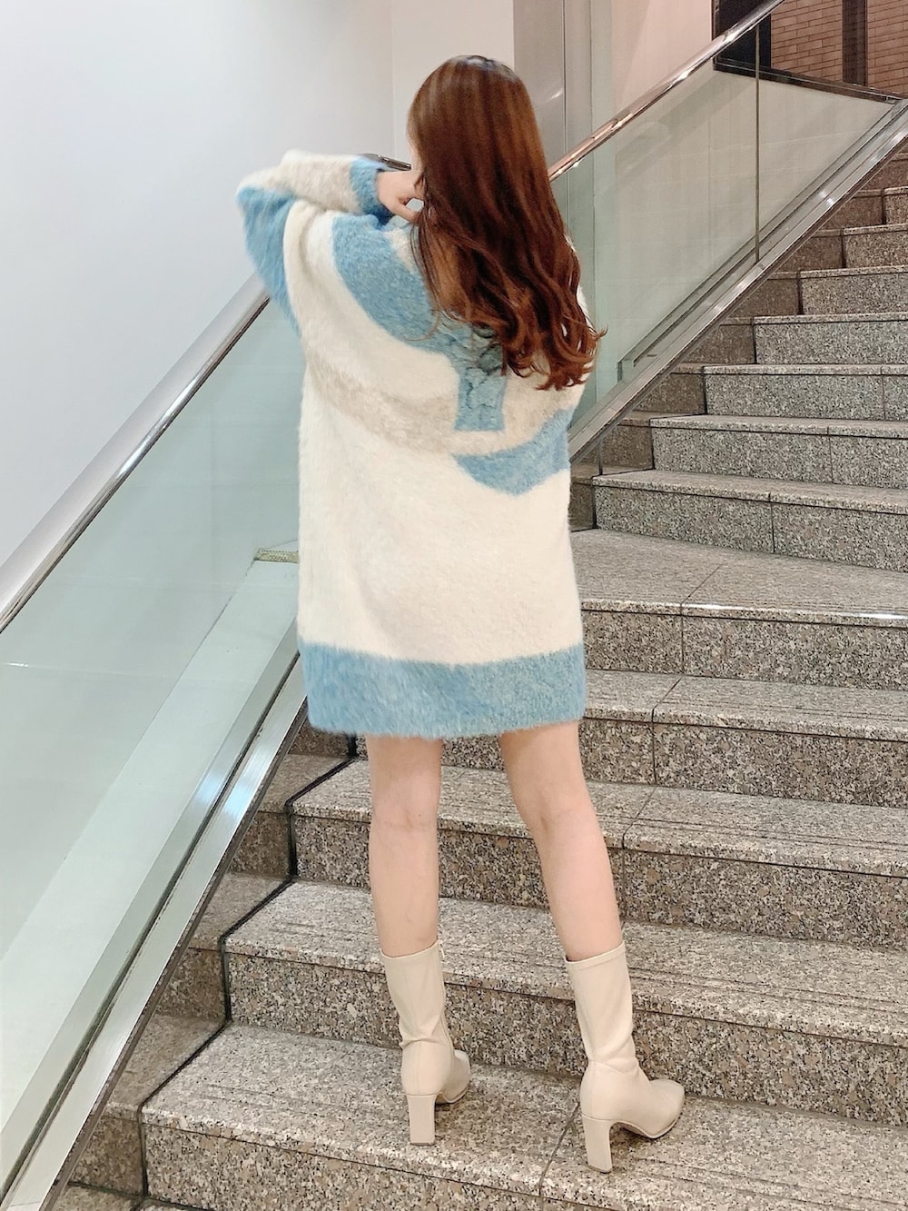 ベージュ系のニット/セーター、ホワイト系のブーツを着用したレディースの秋コーディネートの6枚目の写真