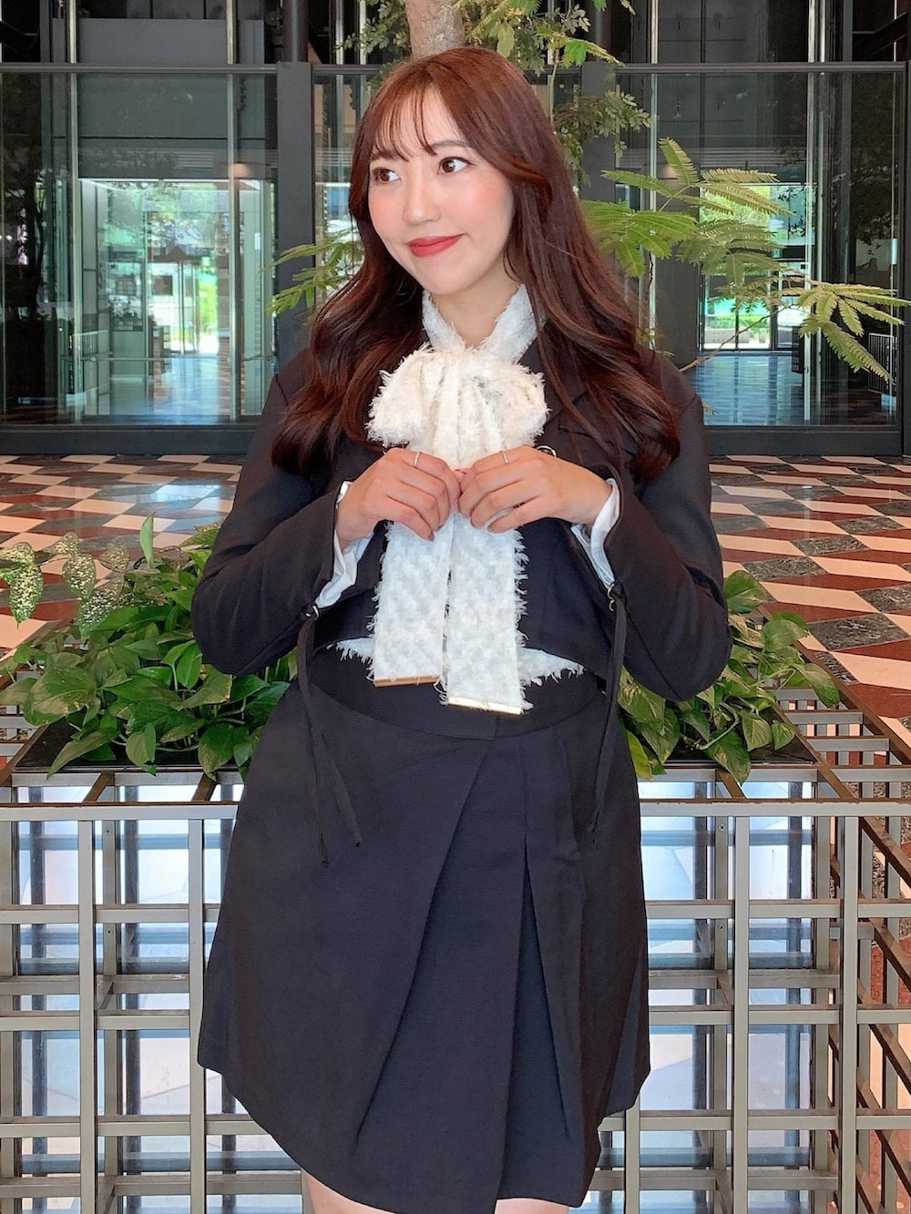 ブラック系のスカート、ブラック系のテーラードジャケット、ベージュ系のブーツを着用したレディースの秋コーディネートの10枚目の写真