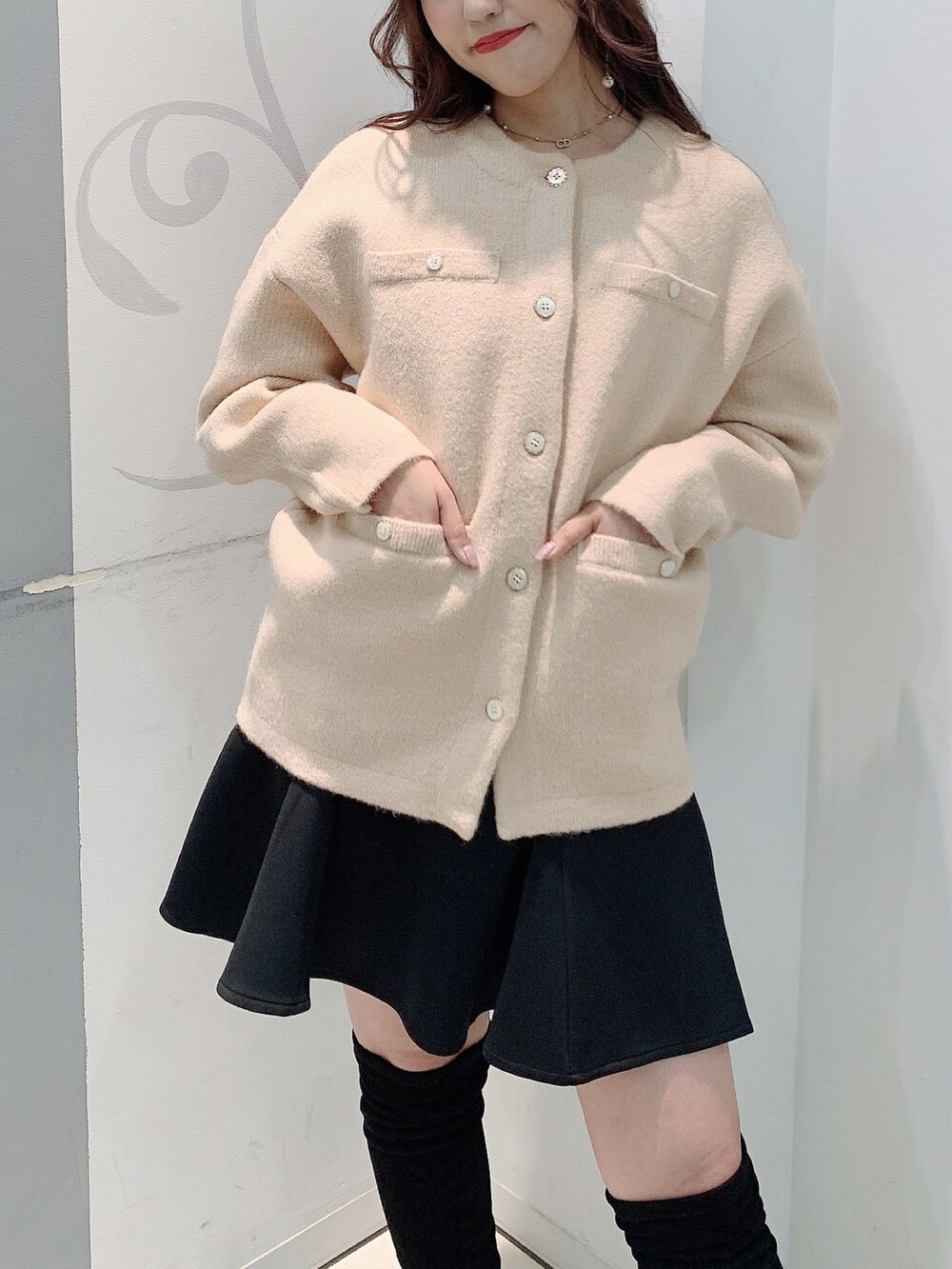 ベージュ系のカーディガン/ボレロ、ブラック系のスカートを着用したレディースの秋コーディネートの3枚目の写真