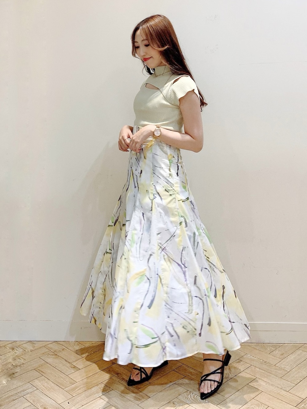 グリーン系のニット/セーター、イエロー系のスカート、ブラック系のサンダルを着用したレディースの夏コーディネートの4枚目の写真