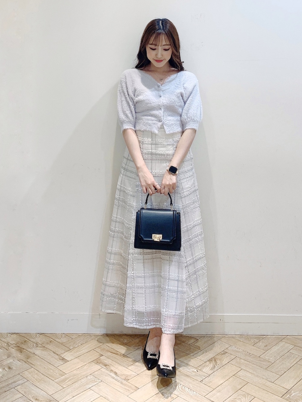 パープル系のカーディガン/ボレロ、ブラック系のスカート、ブラック系のパンプスを着用したレディースの夏コーディネートの4枚目の写真