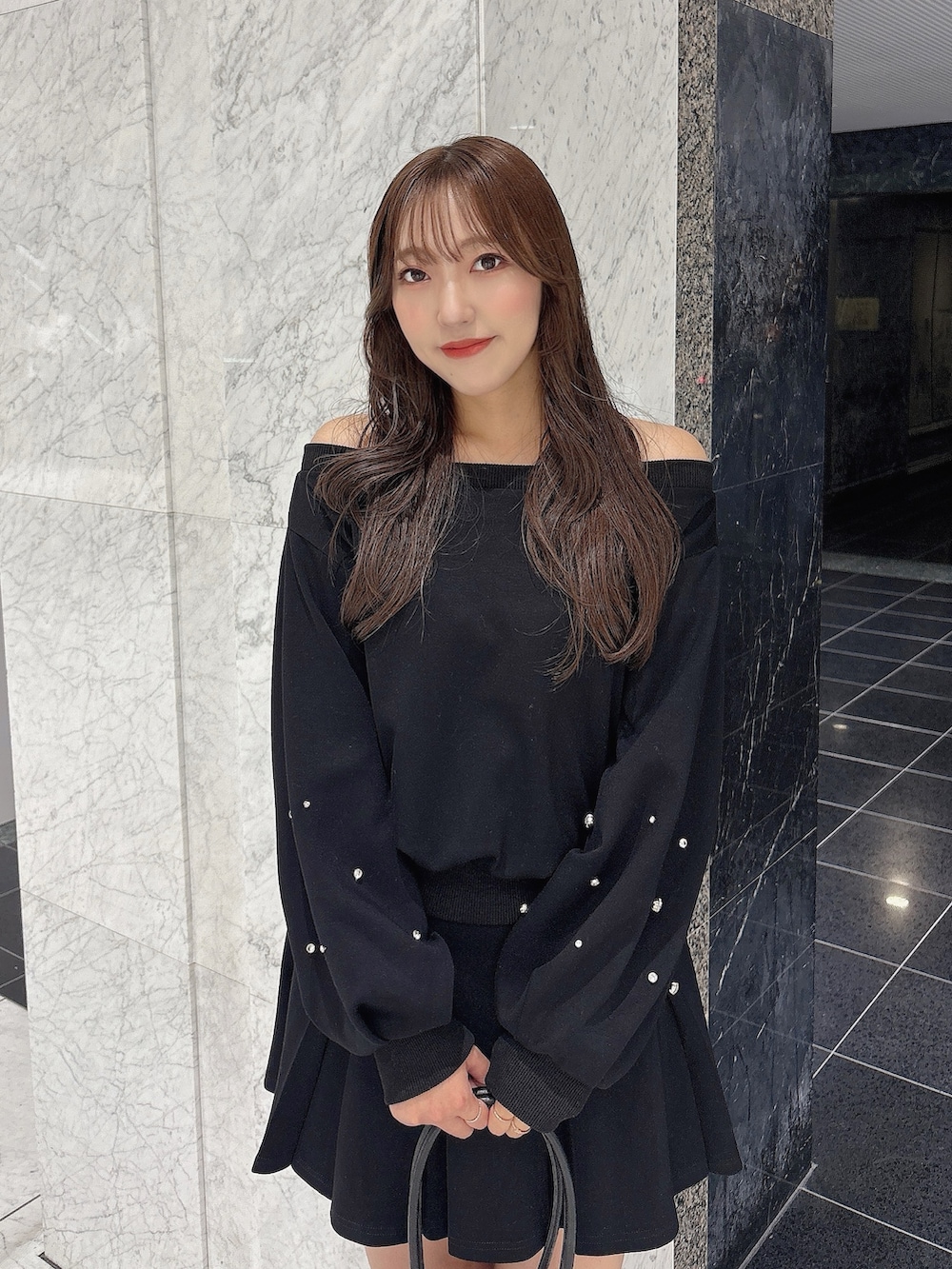 ブラック系のスカート、ブラック系のスウェット、ブラック系のブーツを着用したレディースの秋コーディネートの7枚目の写真