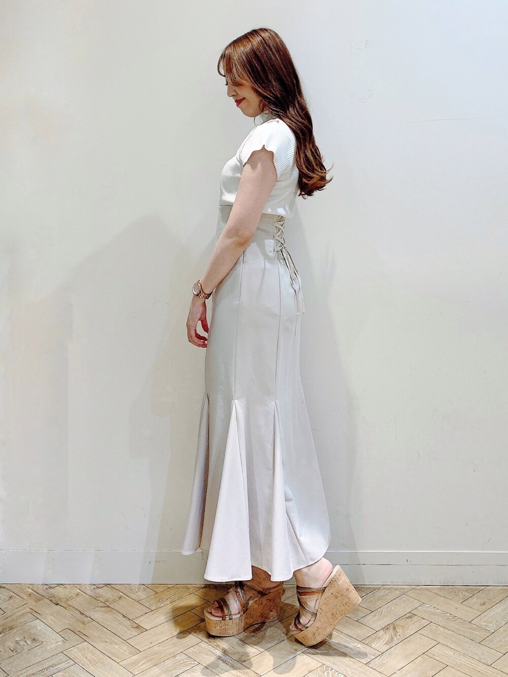 ベージュ系のスカート、ホワイト系のニット/セーター、その他のサンダルを着用したレディースの夏コーディネートの5枚目の写真