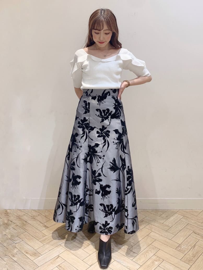 グレー系のスカート、ブラック系のサンダル、ホワイト系のニット/セーターを着用したレディースの夏コーディネートの3枚目の写真