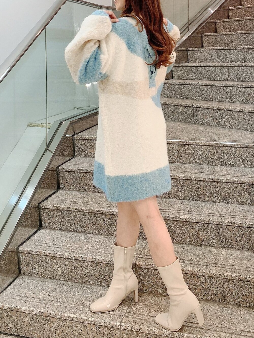 ベージュ系のニット/セーター、ホワイト系のブーツを着用したレディースの秋コーディネートの3枚目の写真