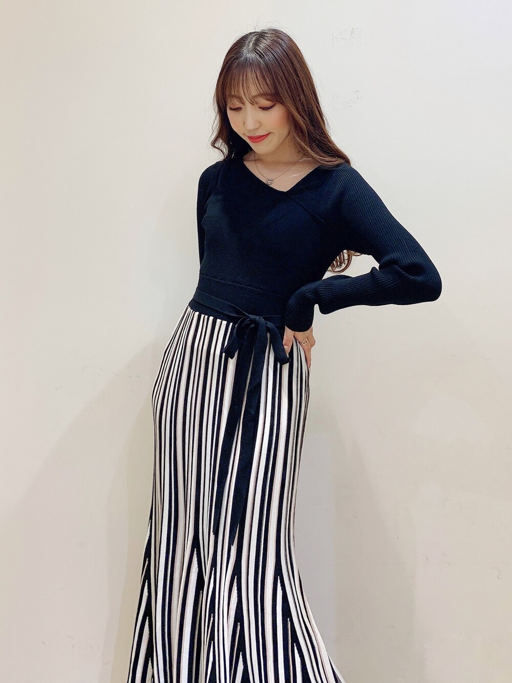 ブラック系のワンピース、ブラック系のダウンジャケット/コート、ホワイト系のブーツを着用したレディースの冬コーディネートの9枚目の写真