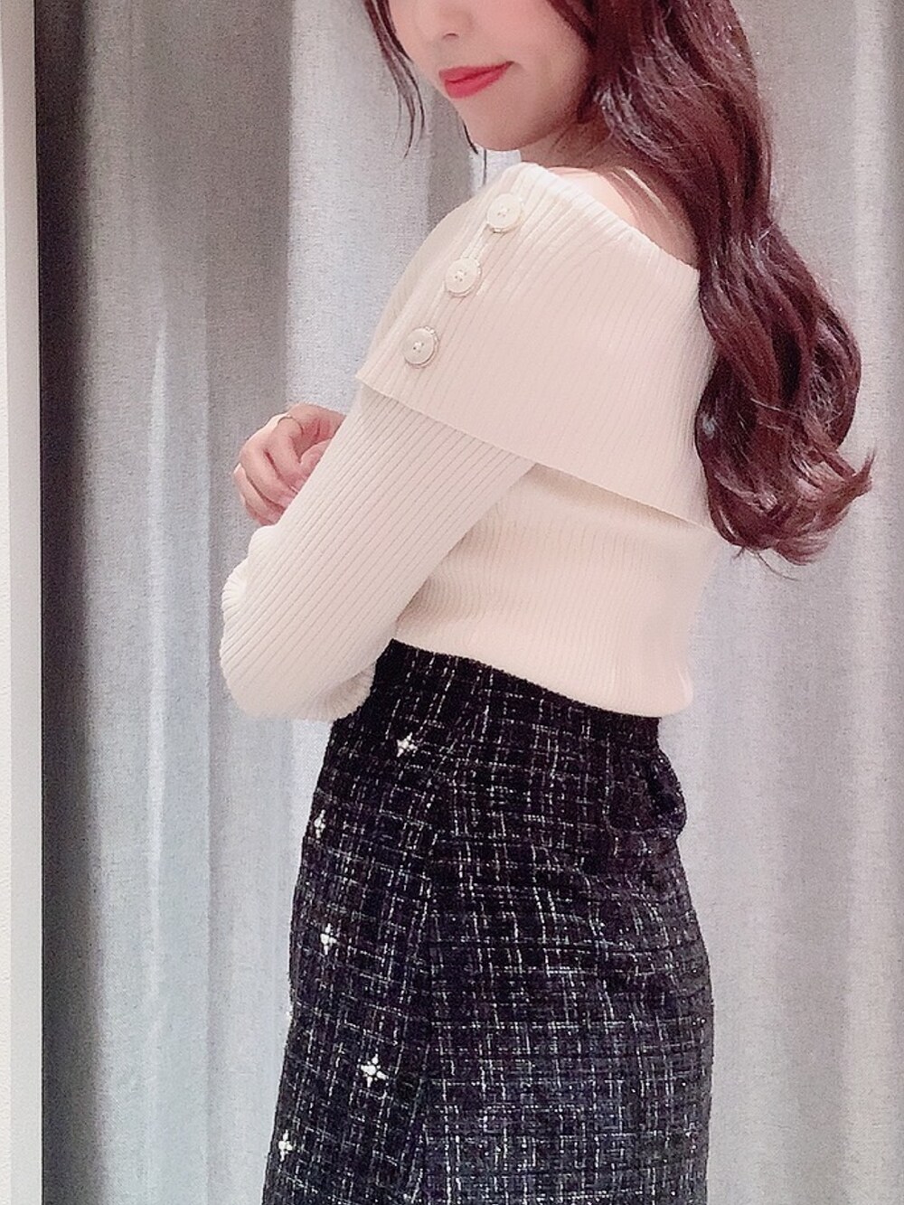 ブラック系のスカート、ブラック系のブーツ、ホワイト系のニット/セーターを着用したレディースの秋コーディネートの7枚目の写真