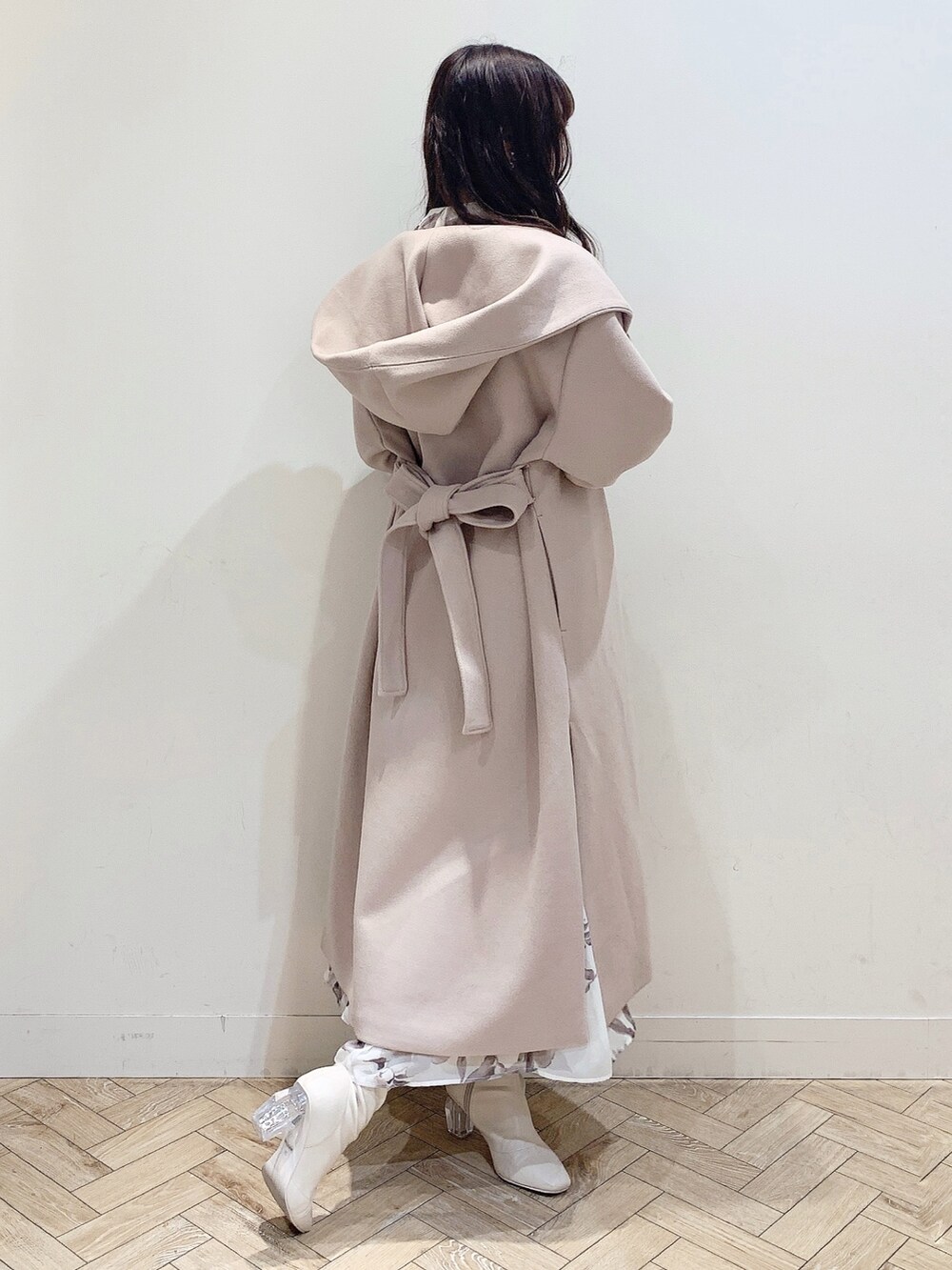 ベージュ系のチェスターコート、ホワイト系のワンピース、ホワイト系のブーツを着用したレディースの冬コーディネートの6枚目の写真