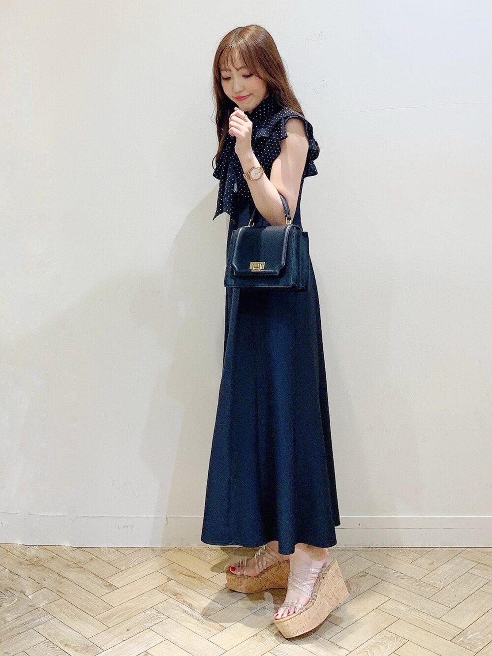 ブラック系のワンピース、その他のサンダル、ブラック系のハンドバッグを着用したレディースの春コーディネートの4枚目の写真