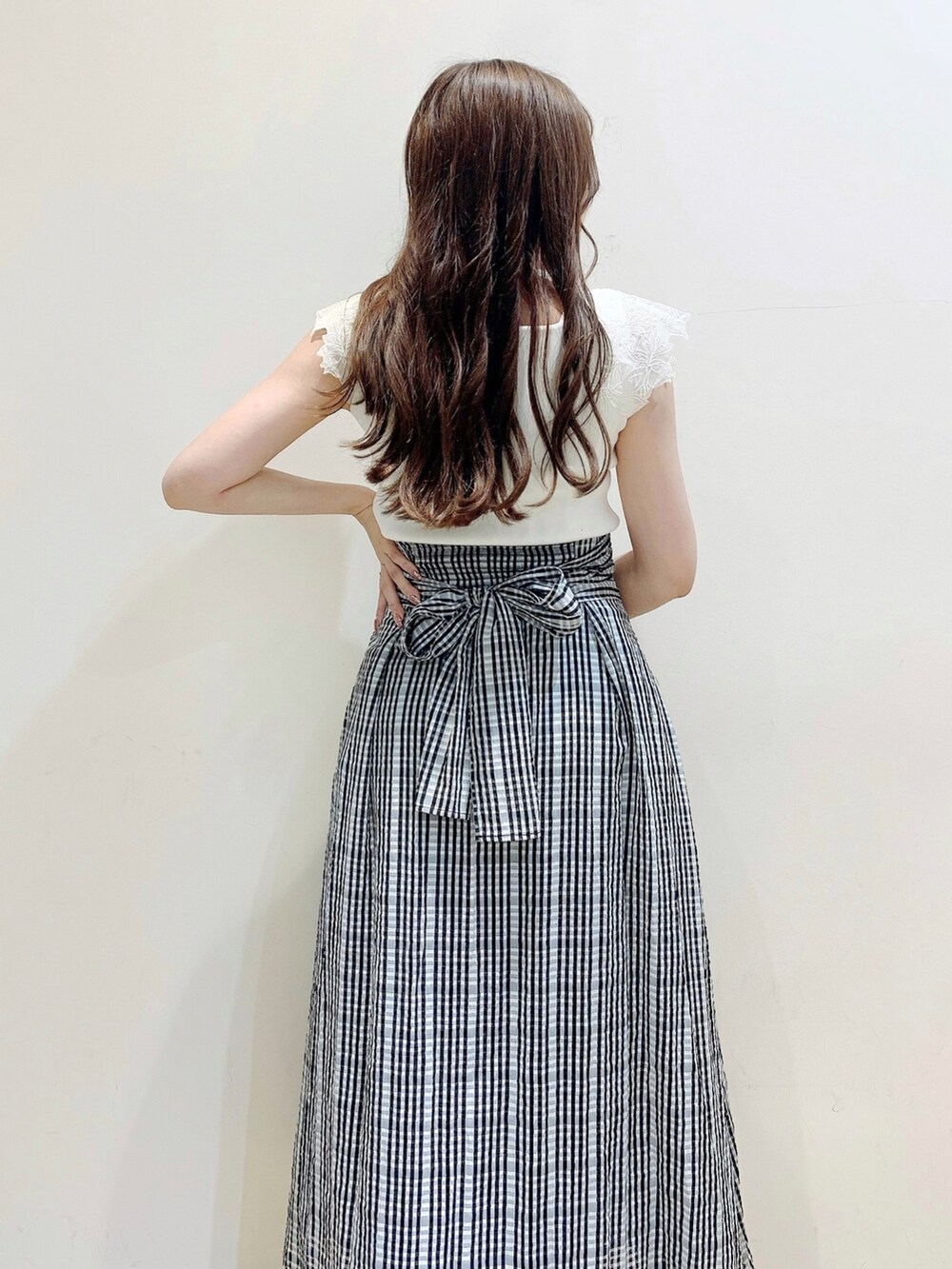 ブラック系のスカート、ホワイト系のニット/セーターを着用したレディースの夏コーディネートの7枚目の写真