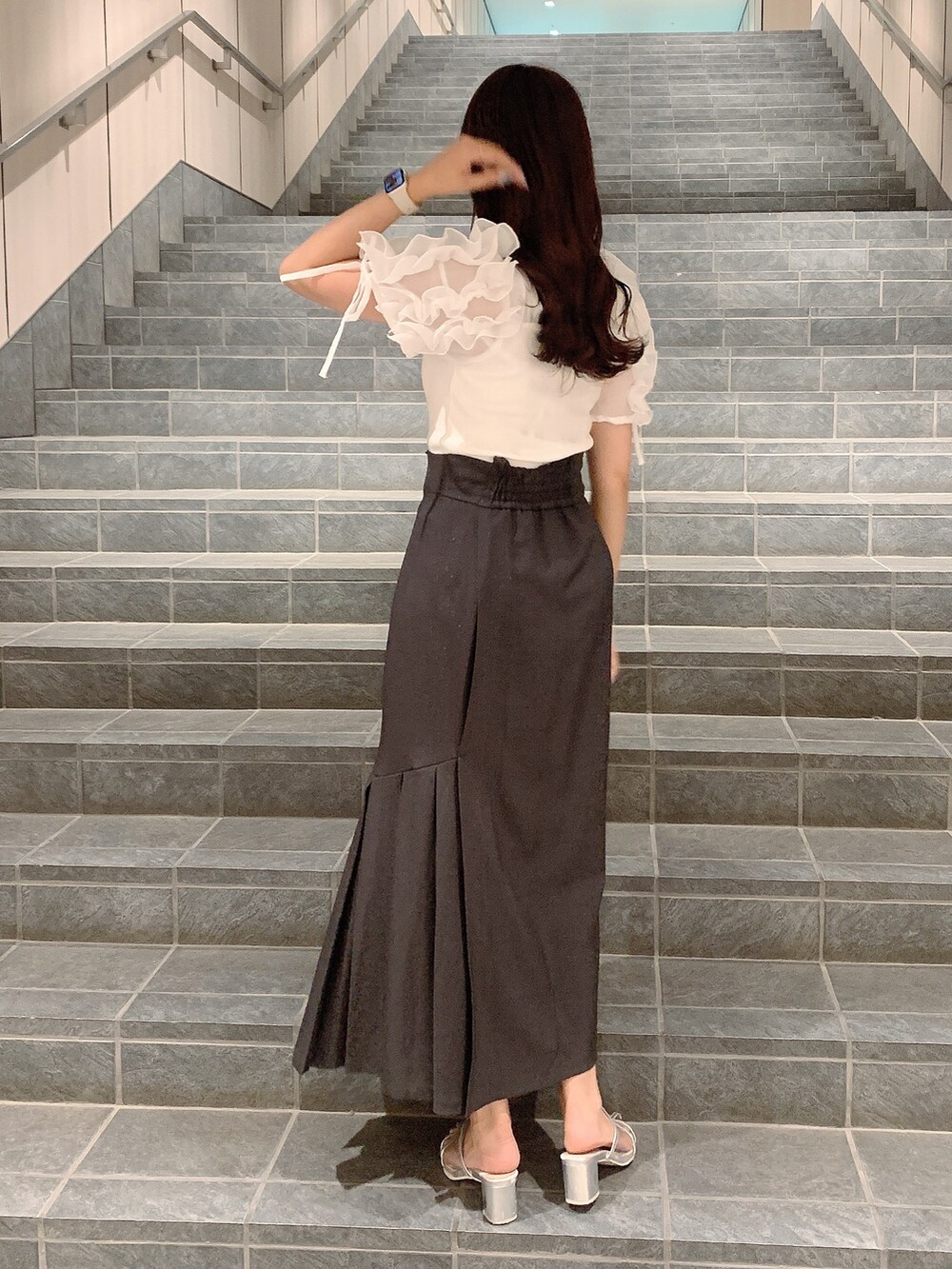 ブラウン系のスカート、シルバー系のパンプス、ホワイト系のTシャツ/カットソーを着用したレディースの夏コーディネートの6枚目の写真