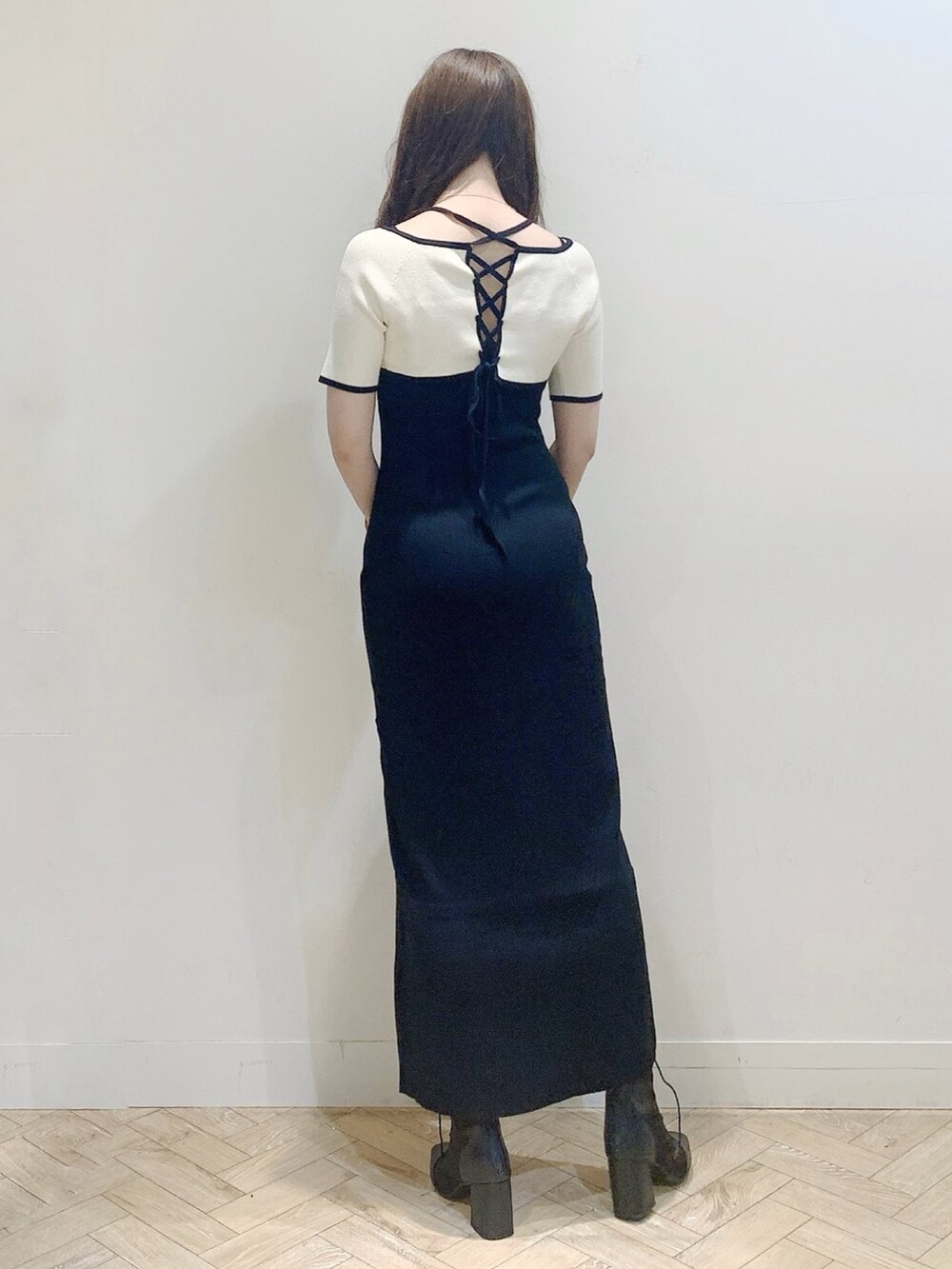 ブラック系のワンピース、シルバー系のハンドバッグ、ブラック系のブーツを着用したレディースの夏コーディネートの6枚目の写真