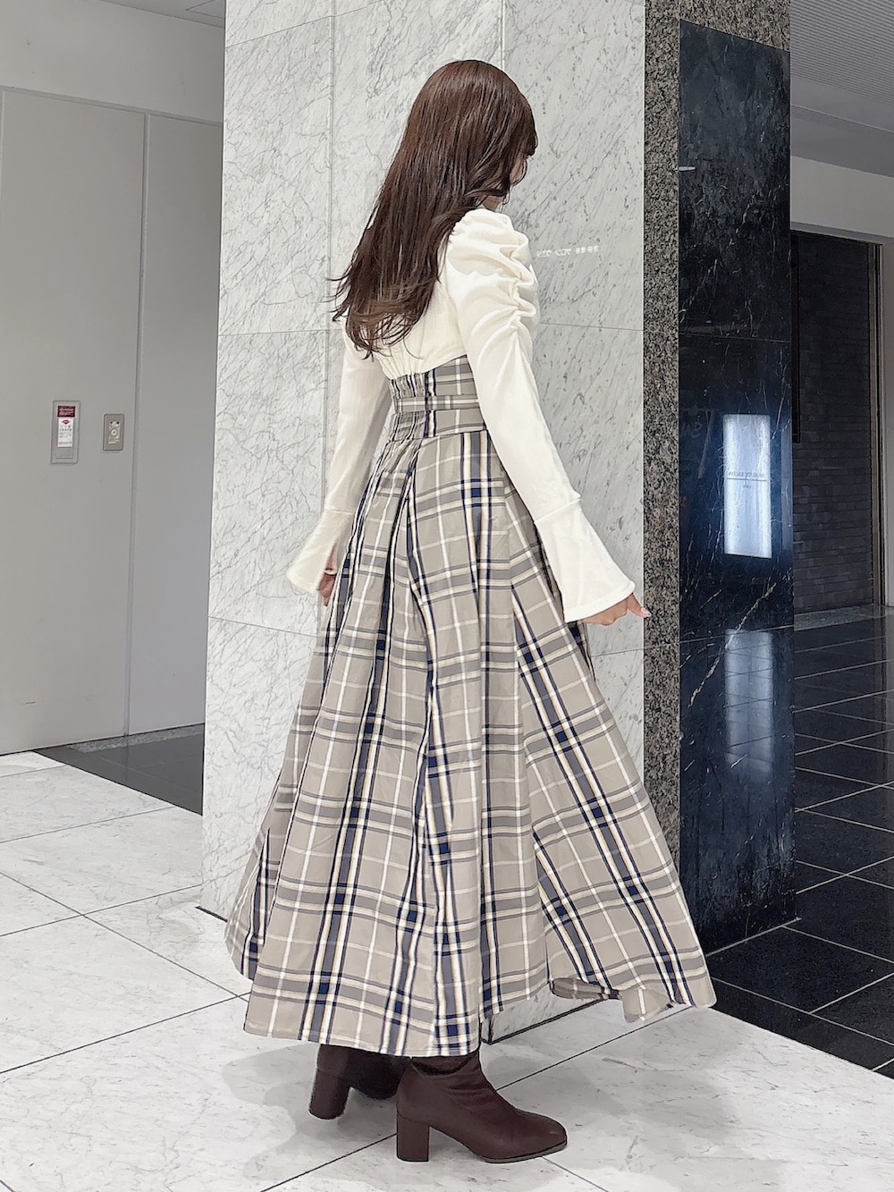 ホワイト系のワンピース、ブラウン系のブーツを着用したレディースの秋コーディネートの3枚目の写真