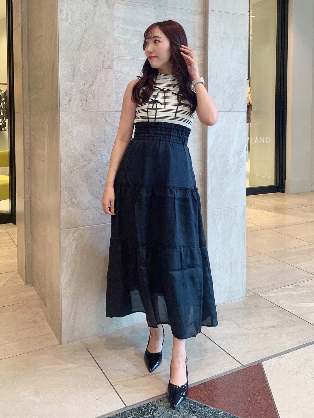 ブラック系のパンプス、ブラック系のワンピースを着用したレディースの夏コーディネートの3枚目の写真