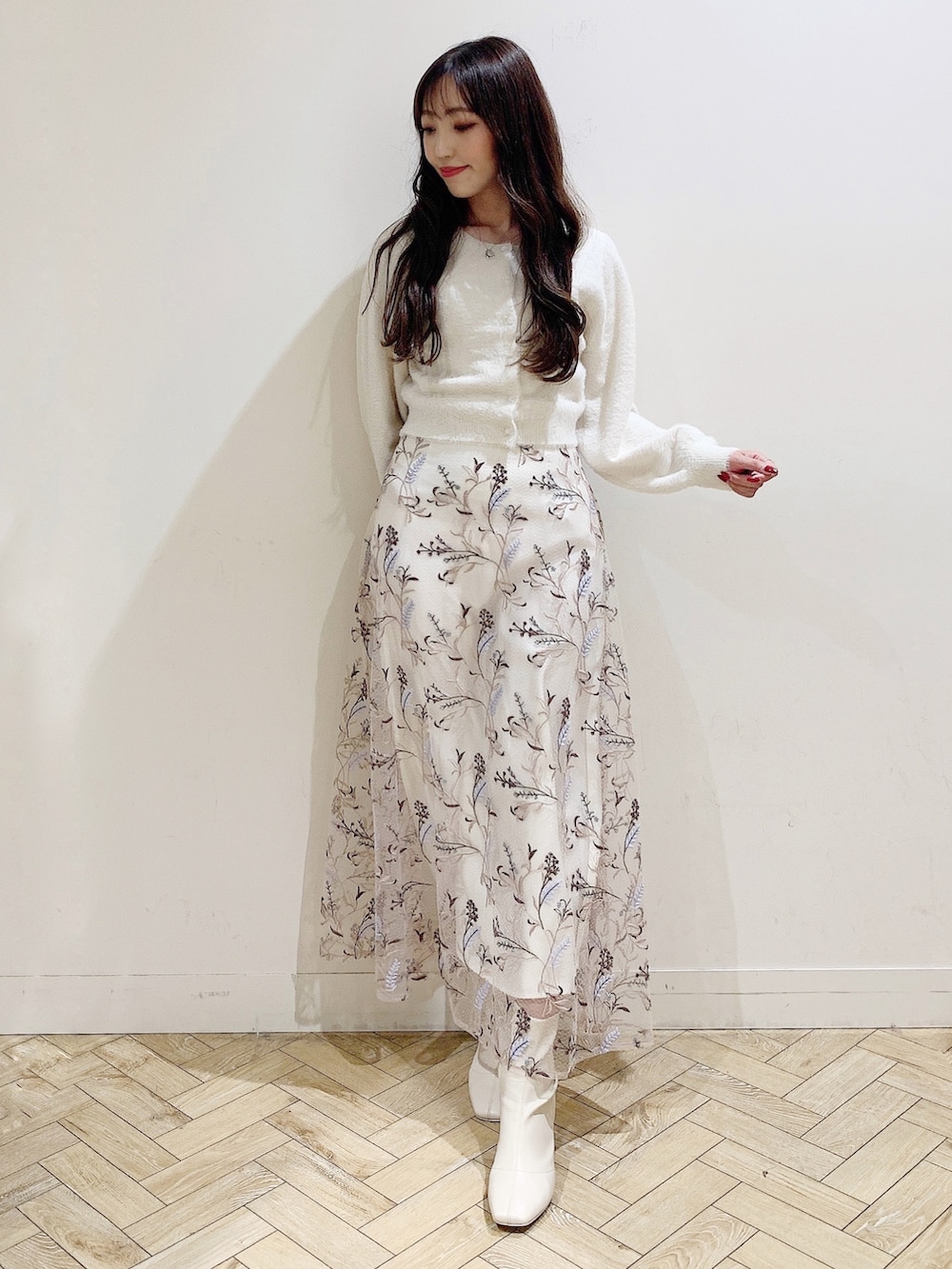 ピンク系のスカート、ホワイト系のカーディガン/ボレロ、ホワイト系のブーツを着用したレディースの秋コーディネートの3枚目の写真