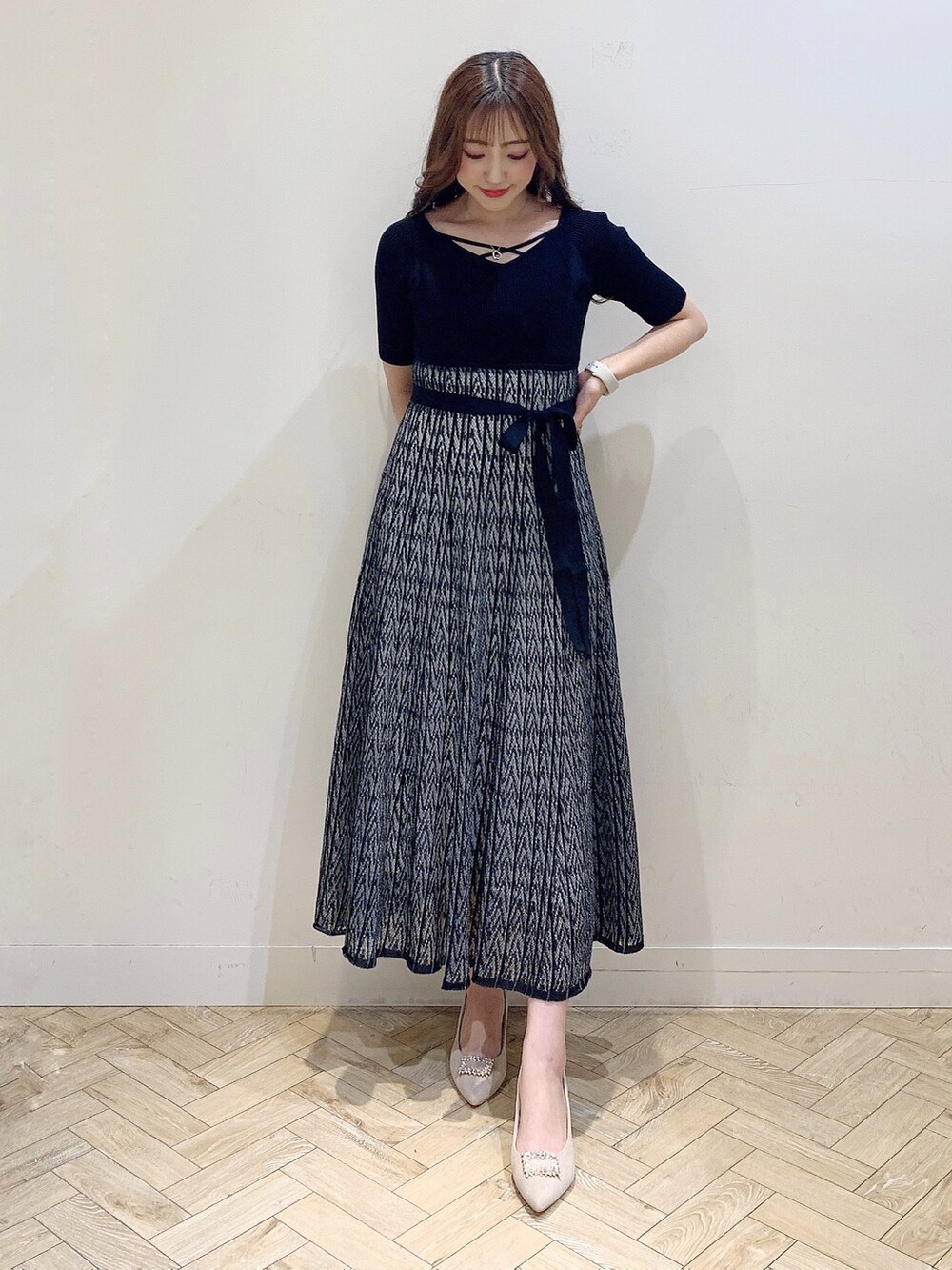ベージュ系のパンプス、ブラック系のワンピースを着用したレディースの夏コーディネートの2枚目の写真