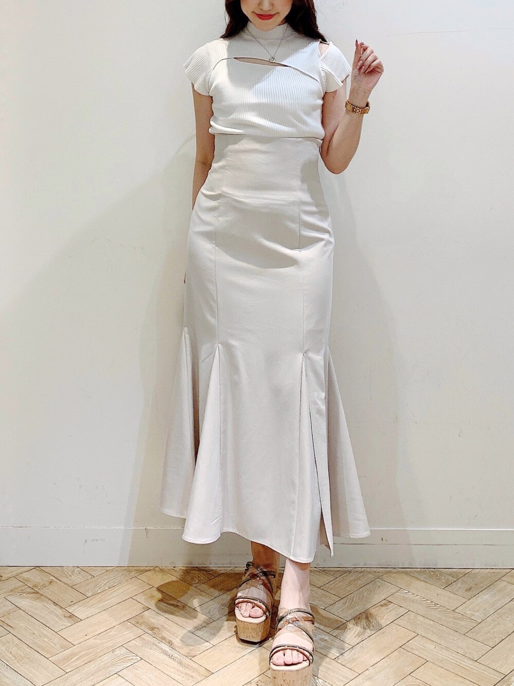 ベージュ系のスカート、ホワイト系のニット/セーター、その他のサンダルを着用したレディースの夏コーディネートの2枚目の写真