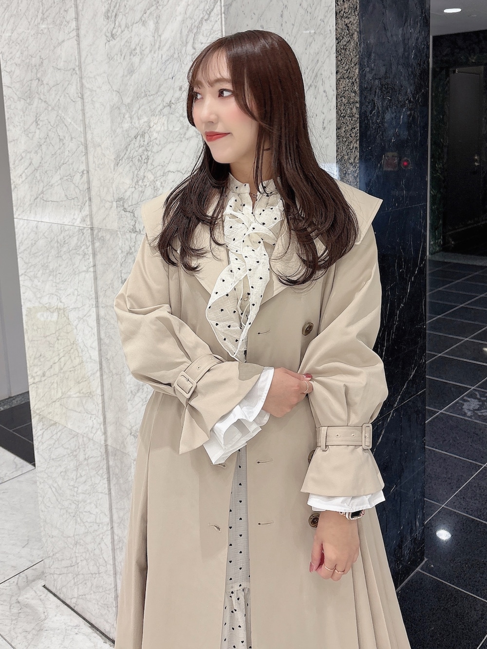 ホワイト系のブーツ、ベージュ系のトレンチコート、ホワイト系のワンピースを着用したレディースの冬コーディネートの8枚目の写真