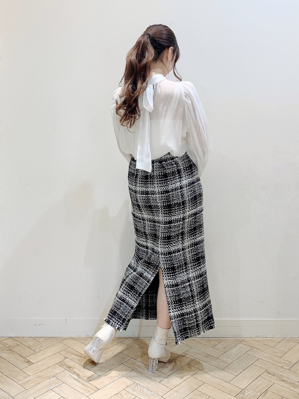 ブラック系のダウンジャケット/コート、ホワイト系のシャツ/ブラウス、ブラック系のスカートを着用したレディースの冬コーディネートの6枚目の写真