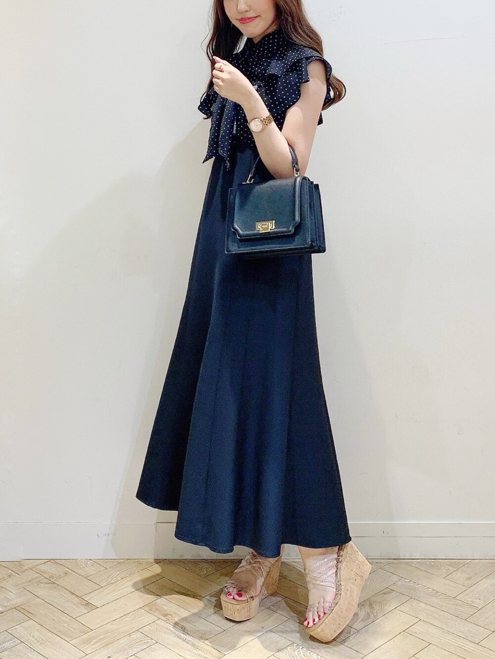 ブラック系のワンピース、その他のサンダル、ブラック系のハンドバッグを着用したレディースの春コーディネートの3枚目の写真