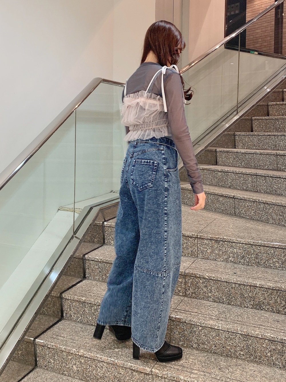 ピンク系のキャミソール、その他のデニムパンツ、ブラック系のブーツを着用したレディースの冬コーディネートの6枚目の写真