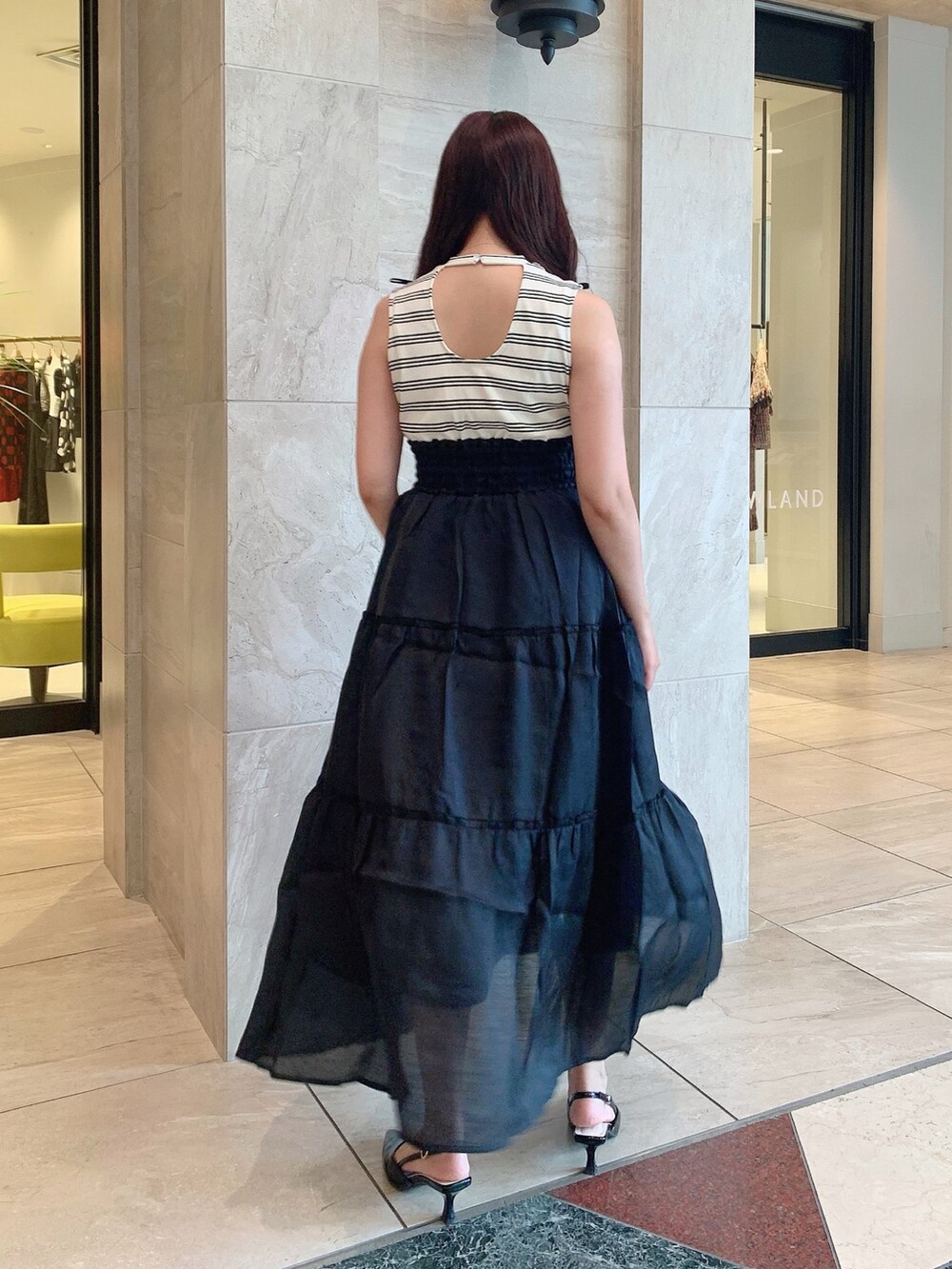 ブラック系のパンプス、ブラック系のワンピースを着用したレディースの夏コーディネートの6枚目の写真