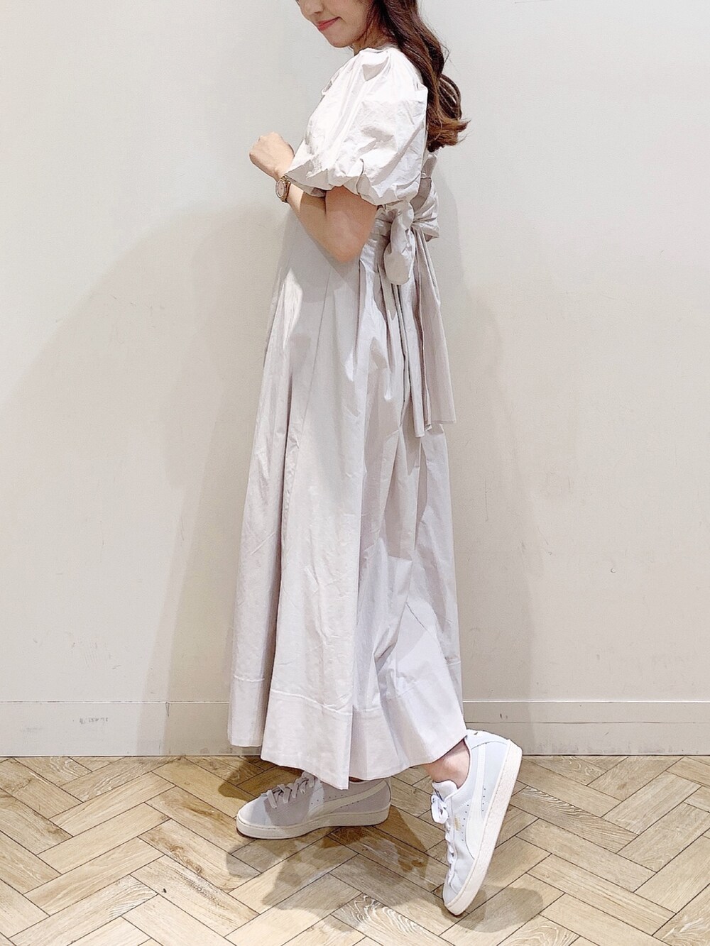 ホワイト系のワンピース、グレー系のスニーカーを着用したレディースの春コーディネートの3枚目の写真