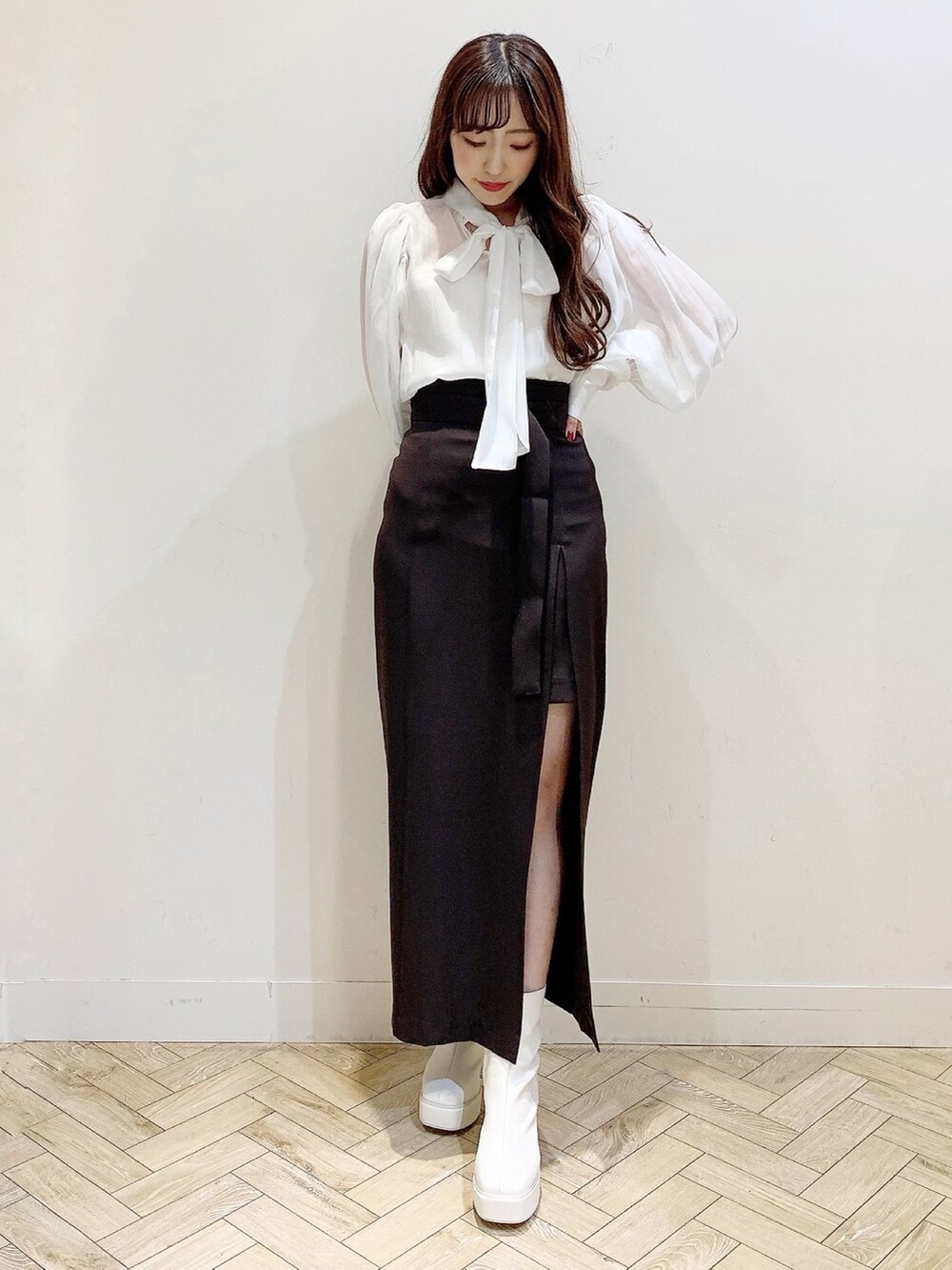 ブラウン系のスカート、ホワイト系のブーツ、ホワイト系のシャツ/ブラウスを着用したレディースの秋コーディネートの7枚目の写真