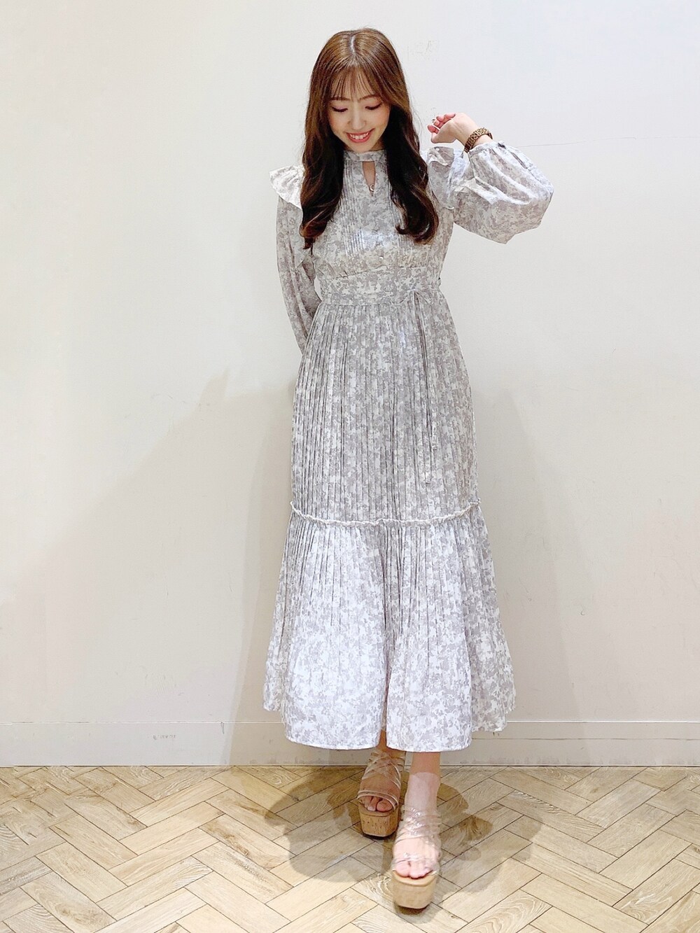 グレー系のワンピース、その他のサンダル、ホワイト系のトレンチコートを着用したレディースの春コーディネートの2枚目の写真