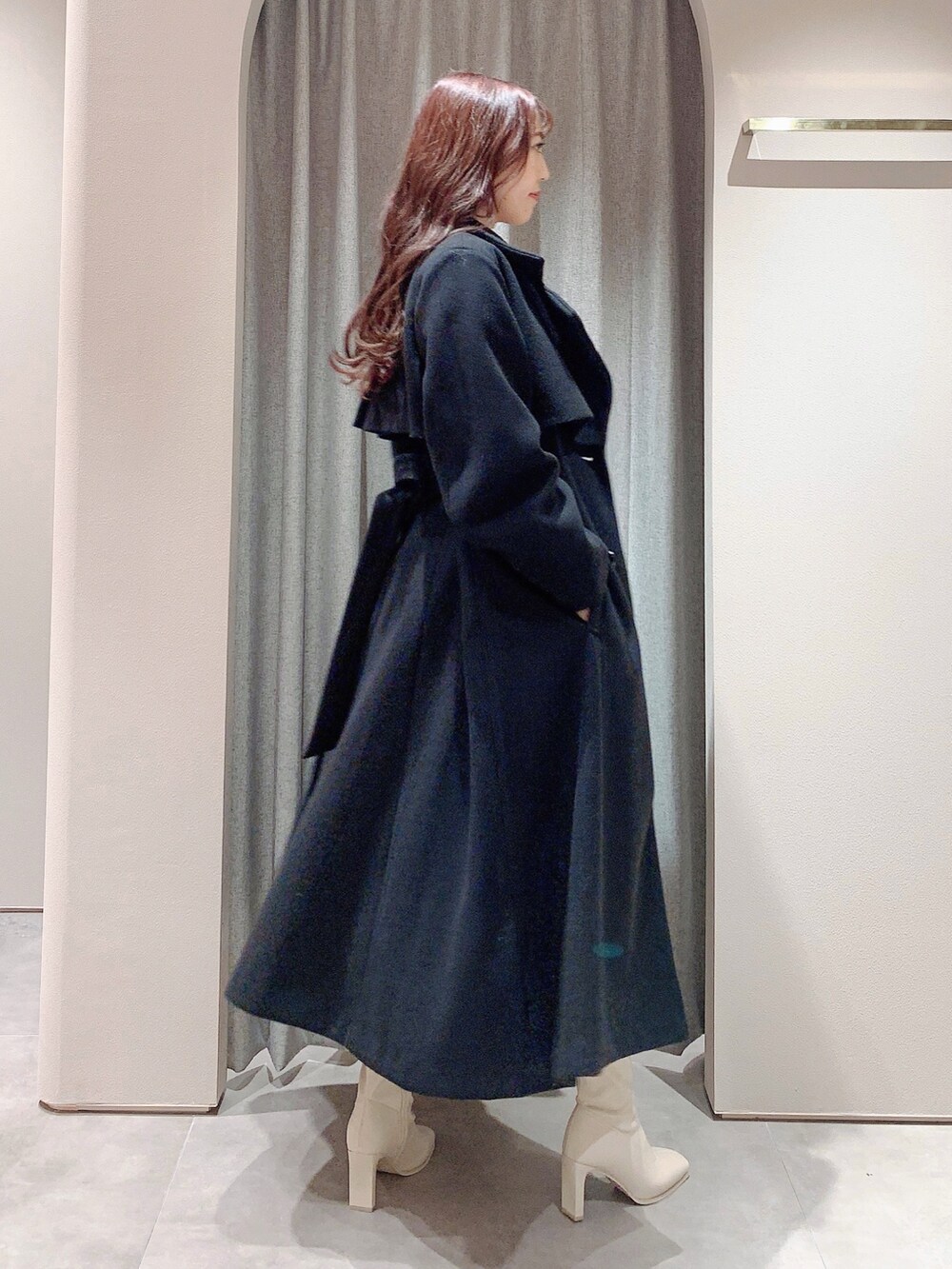 ホワイト系のワンピース、ホワイト系のブーツ、ブラック系のその他アウターを着用したレディースの冬コーディネートの3枚目の写真