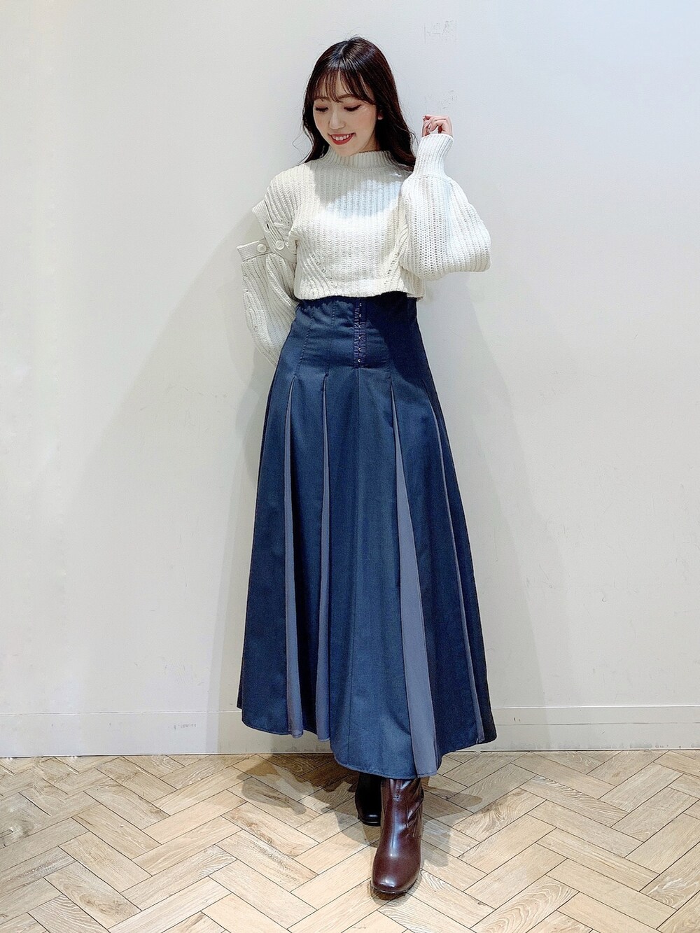 グレー系のスカート、ホワイト系のワンピース、ブラウン系のブーツを着用したレディースの冬コーディネートの6枚目の写真