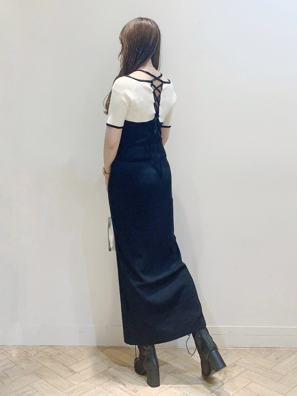 ブラック系のワンピース、シルバー系のハンドバッグ、ブラック系のブーツを着用したレディースの夏コーディネートの7枚目の写真