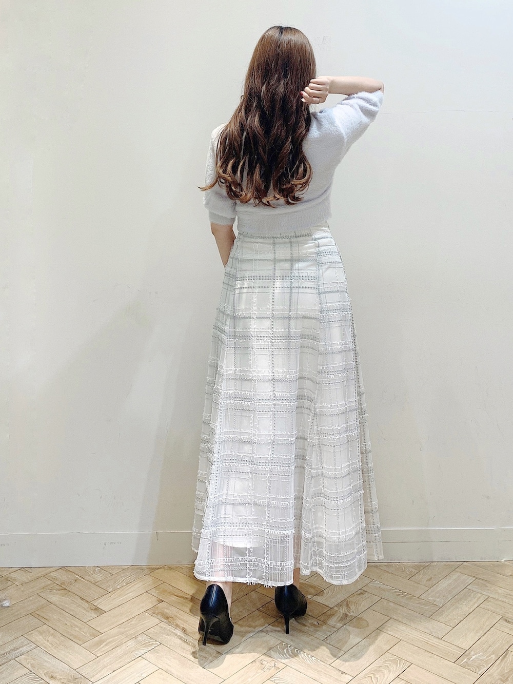 パープル系のカーディガン/ボレロ、ブラック系のスカート、ブラック系のパンプスを着用したレディースの夏コーディネートの6枚目の写真