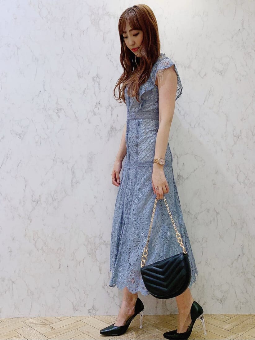 ブルー系のドレス、ブラック系のパンプス、ブラック系のハンドバッグを着用したレディースの夏コーディネートの3枚目の写真