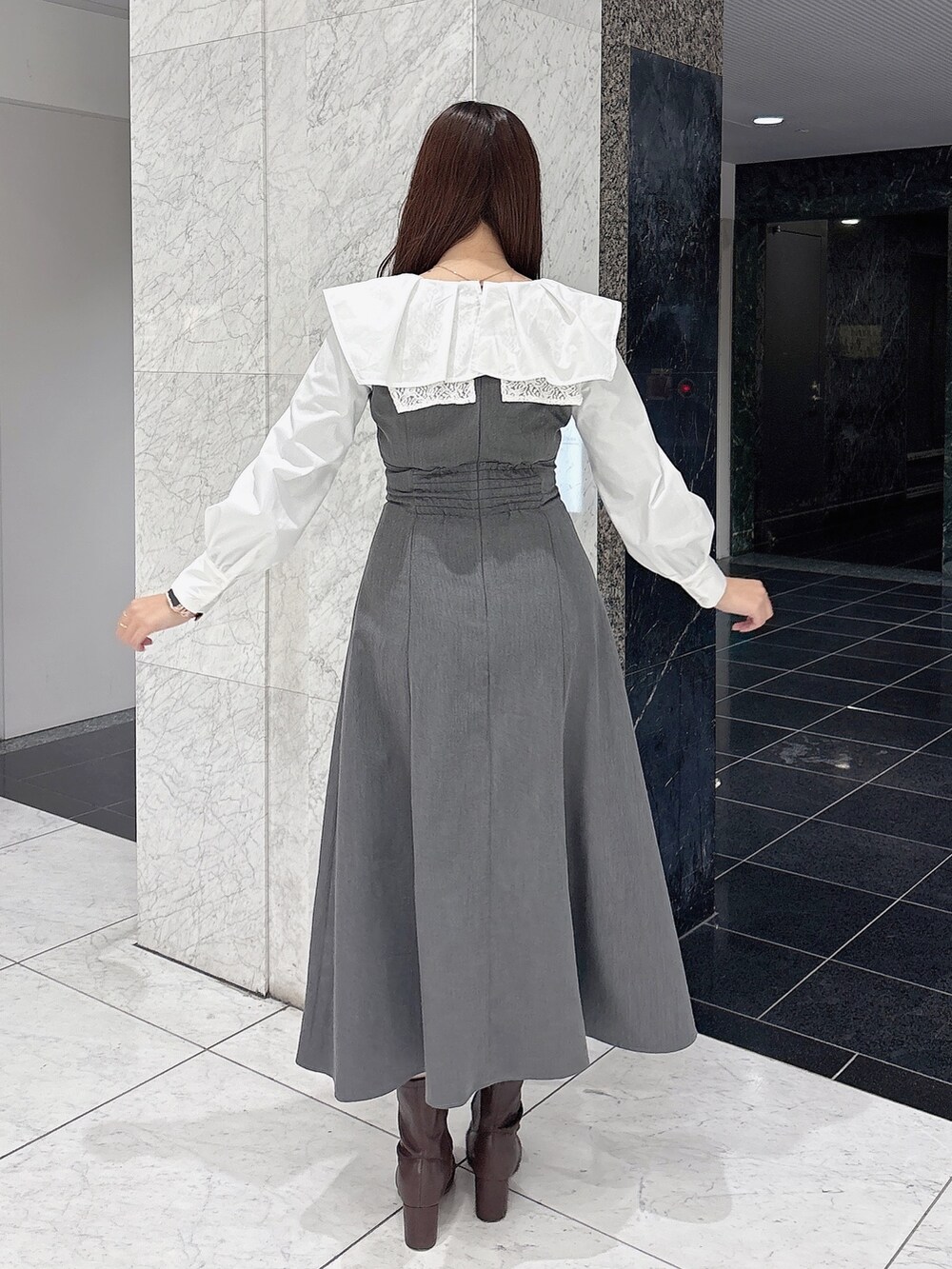 グレー系のワンピース、ブラウン系のブーツを着用したレディースの冬コーディネートの4枚目の写真