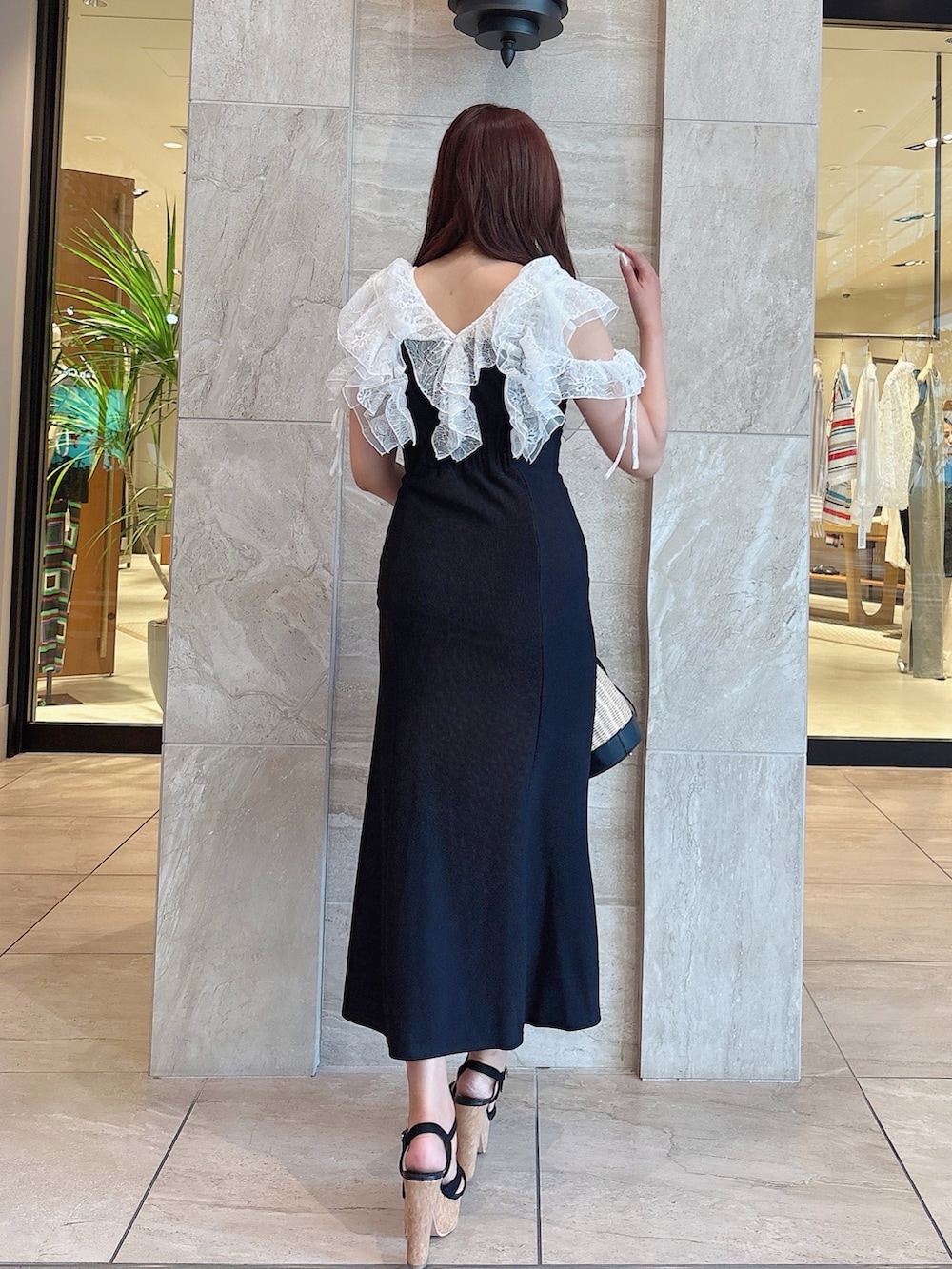 ブラック系のワンピース、ブラック系のサンダル、ブラック系のかごバッグを着用したレディースの夏コーディネートの7枚目の写真