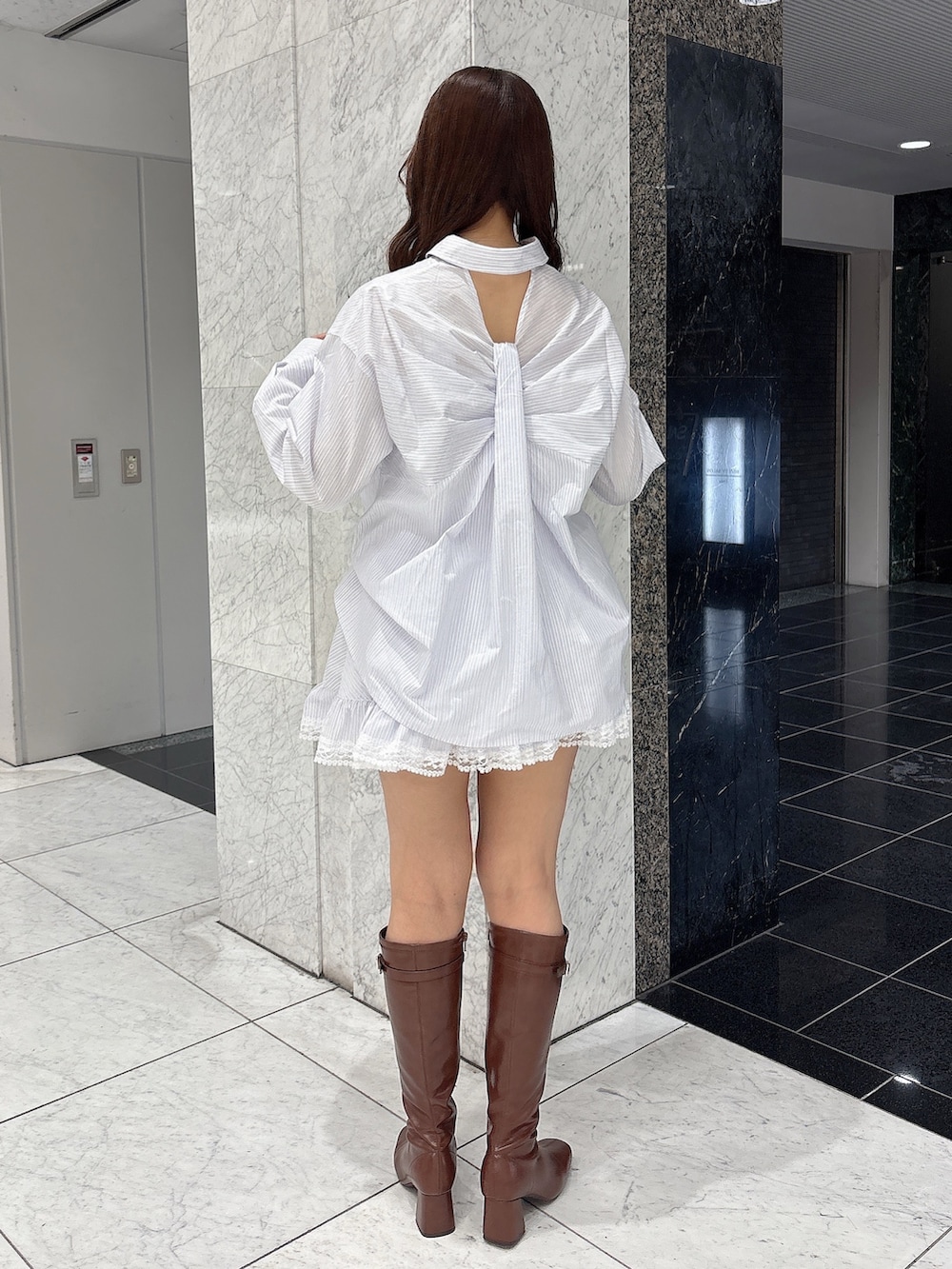 ブラウン系のブーツ、ホワイト系のシャツ/ブラウス、ホワイト系のスカートを着用したレディースの春コーディネートの4枚目の写真