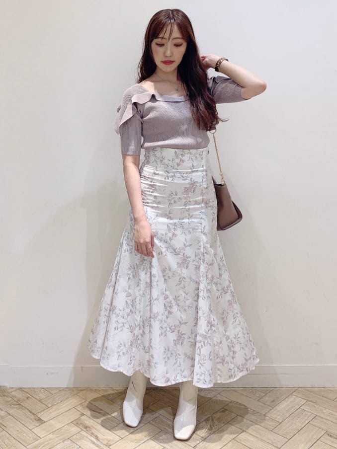 ホワイト系のブーツ、ブラウン系のハンドバッグ、ベージュ系のニット/セーターを着用したレディースの夏コーディネートの3枚目の写真