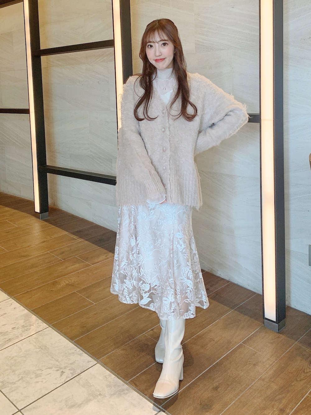 ベージュ系のスカート、ブラウン系のカーディガン/ボレロ、ホワイト系のブーツを着用したレディースの冬コーディネートの3枚目の写真