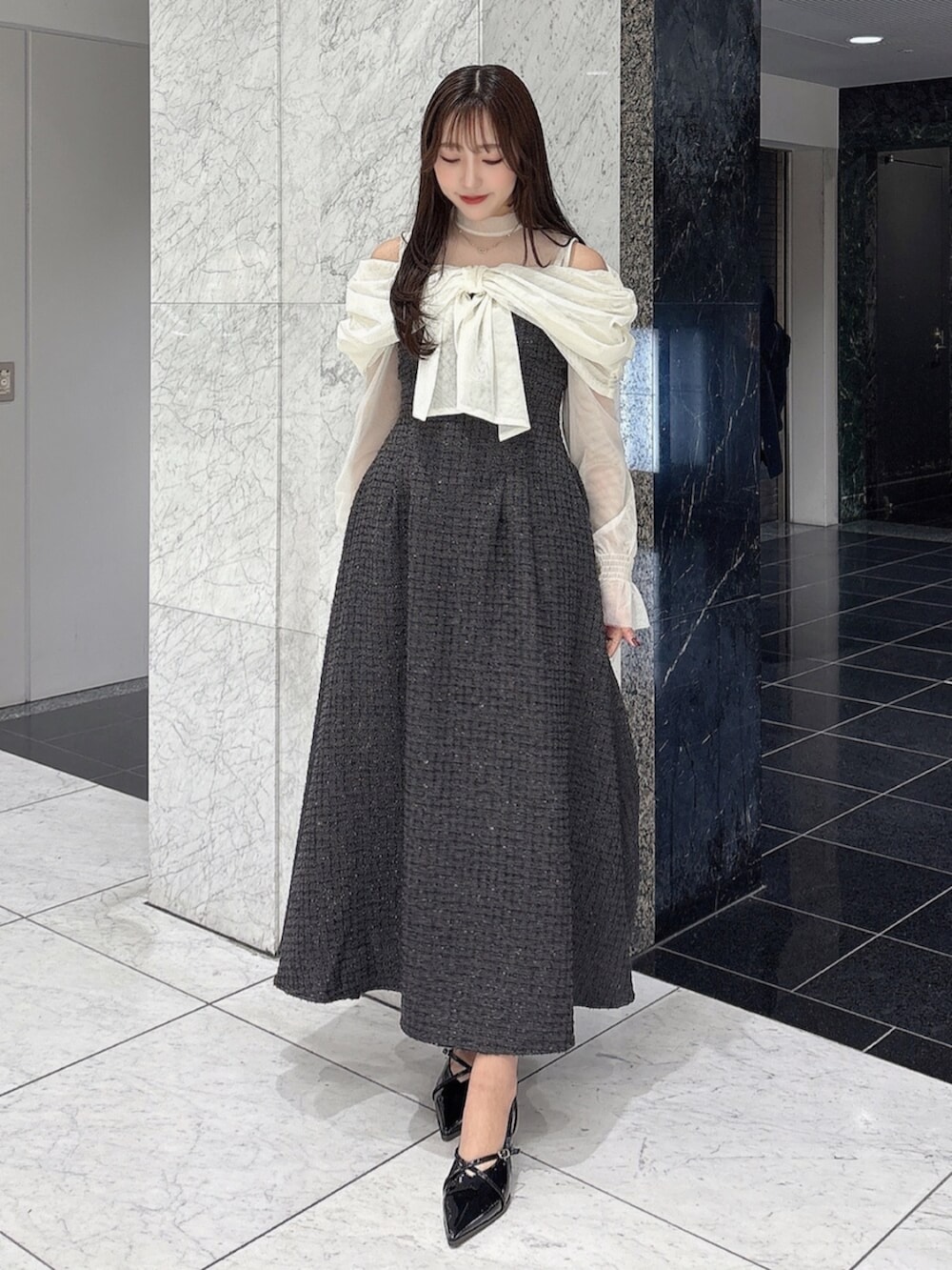 ブラック系のパンプス、ブラック系のドレスを着用したレディースの冬コーディネートの6枚目の写真