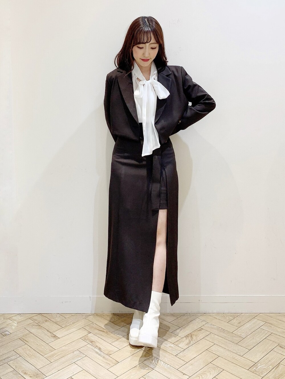 ブラウン系のスカート、ホワイト系のブーツ、ホワイト系のシャツ/ブラウスを着用したレディースの秋コーディネートの3枚目の写真